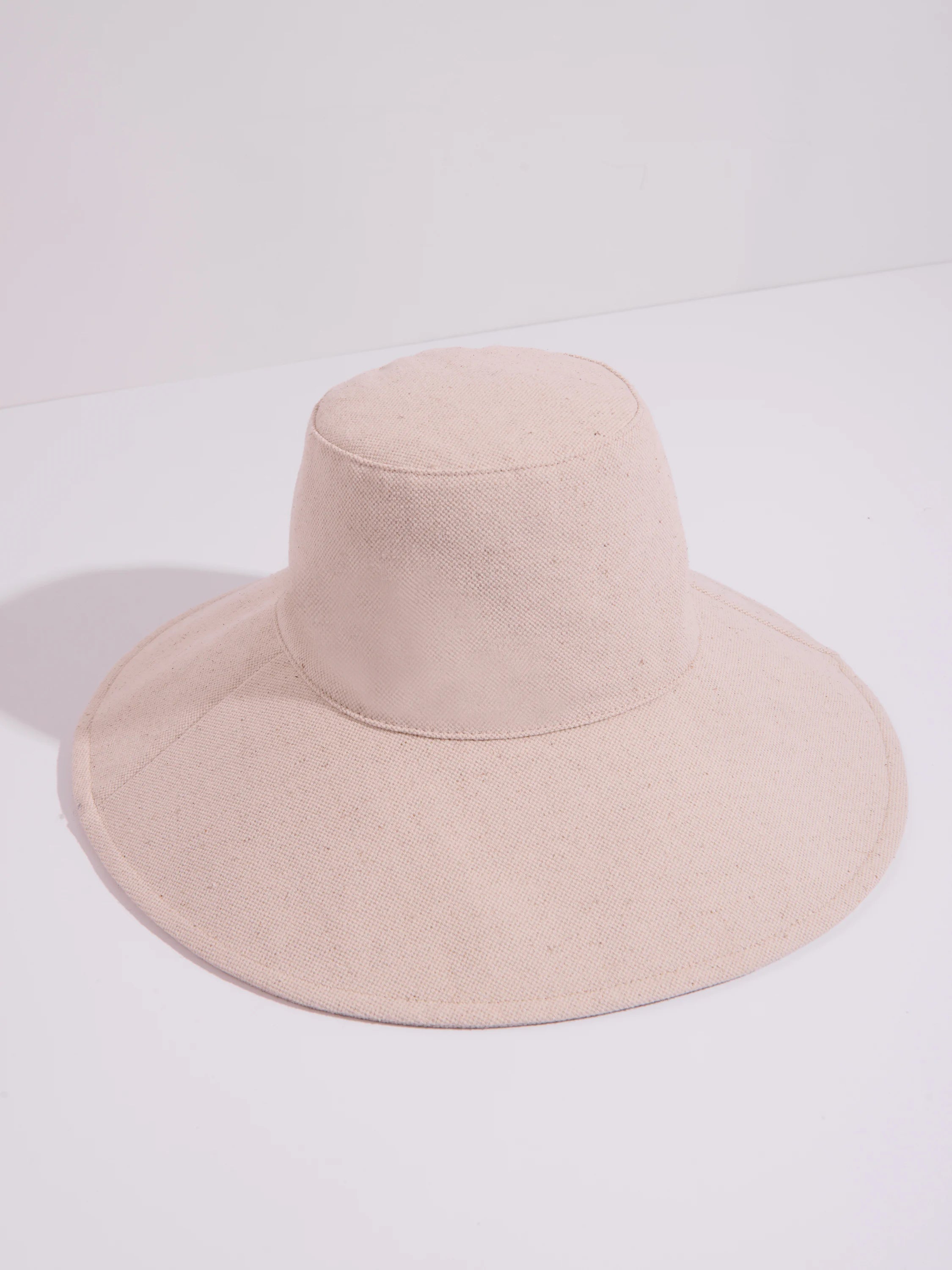 Beige sunhat with a wide brim and short crown.  Simple design, solid color.