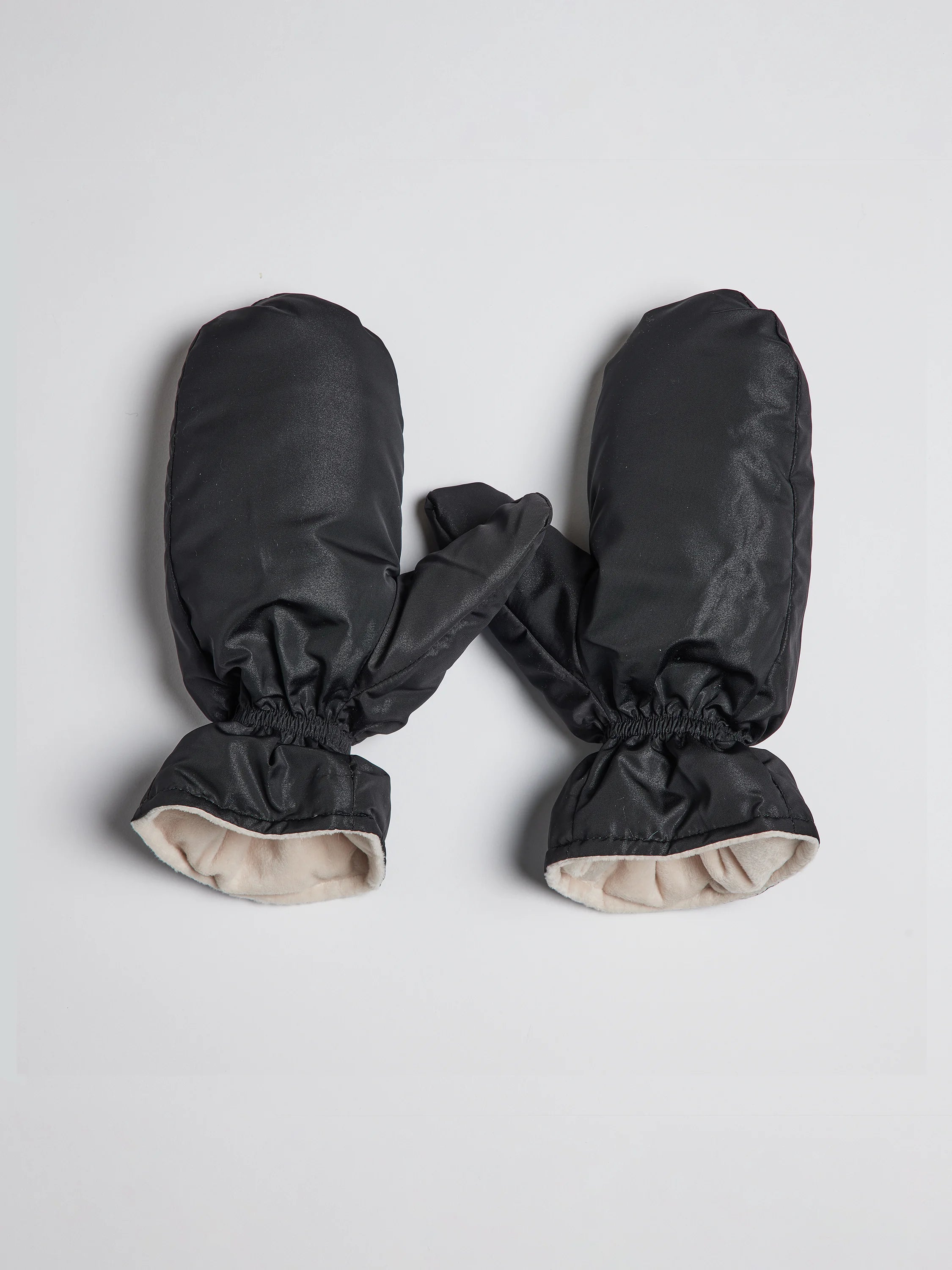 Black mittens with beige lining; shown lying flat.