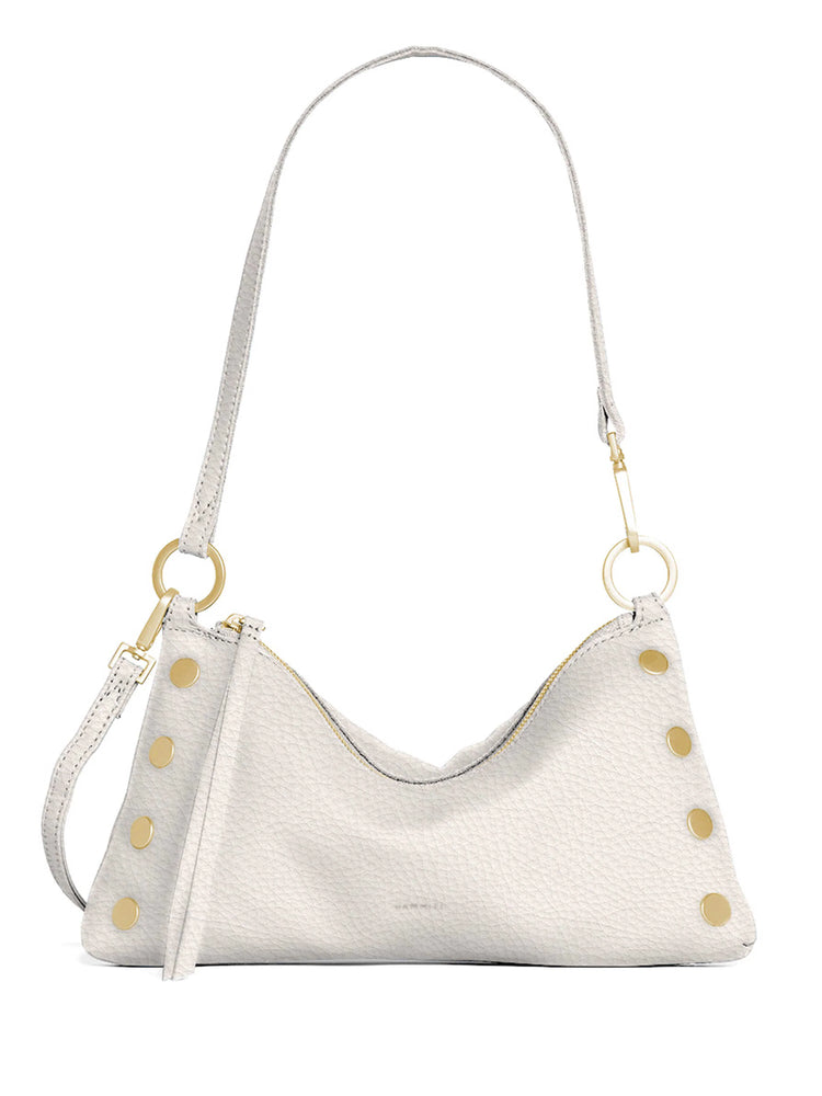 Pale pebbled leather crescent bag with a single shoulder strap, gold zipper, and decorative gold studs.