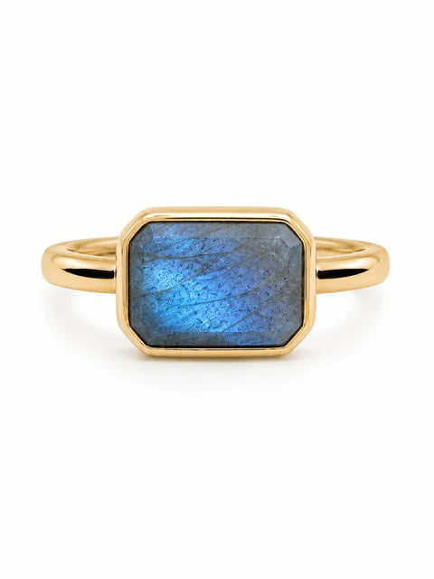 Gold ring with a rectangular, faceted blue-grey iridescent stone.