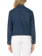 Back view of a dark blue denim cropped jacket. Features visible seam stitching and gold-tone cuff buttons.