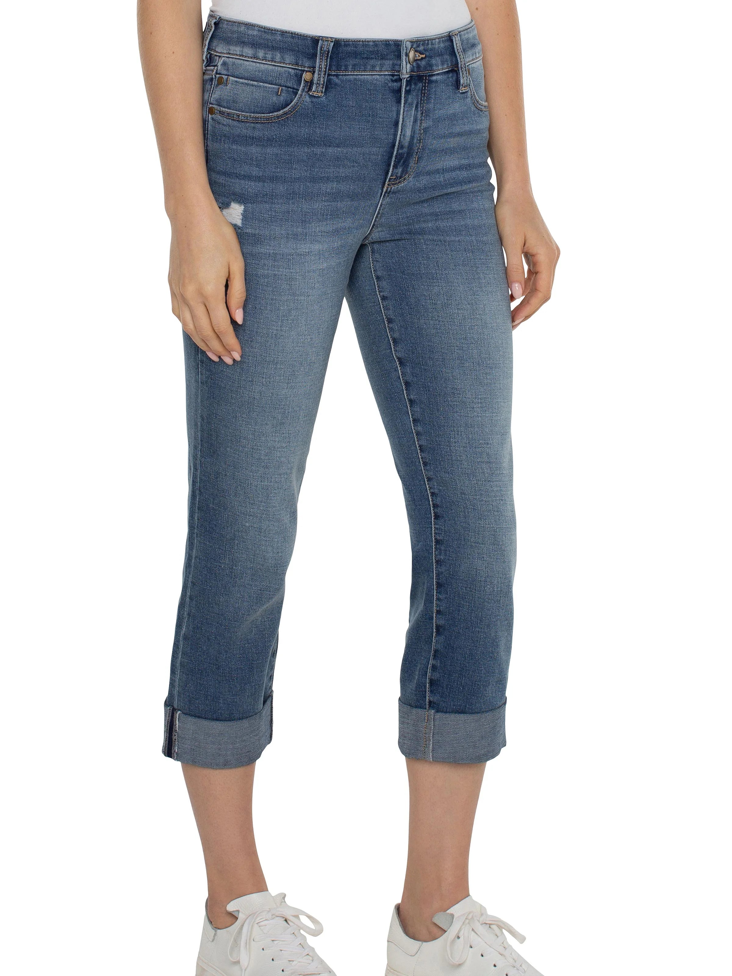 Medium wash blue denim cropped jeans with rolled cuffs. Features light fading and subtle distressing on the thigh.