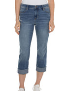 Medium blue wash cropped jeans with rolled hems, slight fading, and distressing on one thigh.