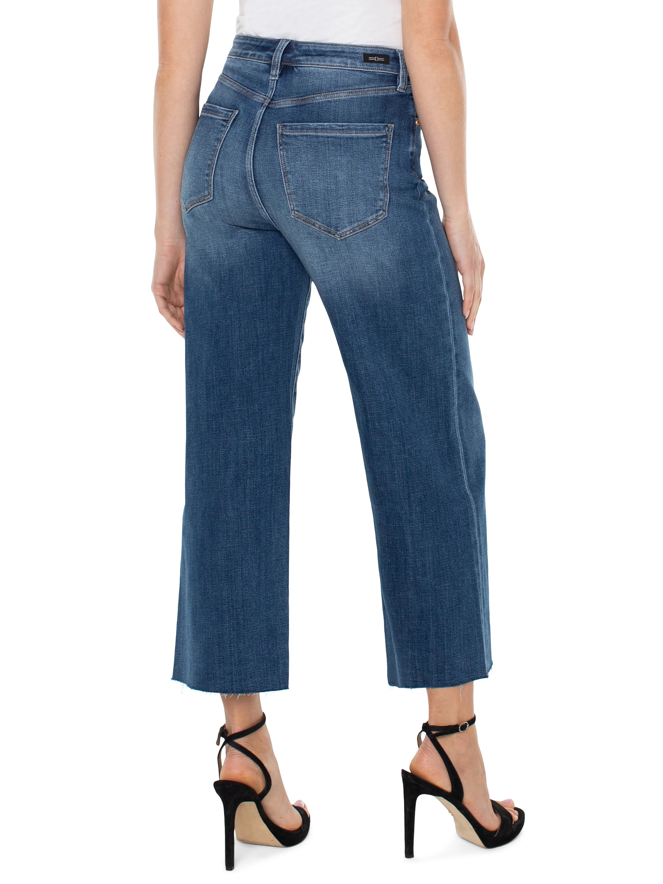 Here's alt text for the image, under 125 characters:
Mid-wash blue, wide-leg jeans with frayed hems. View from the...