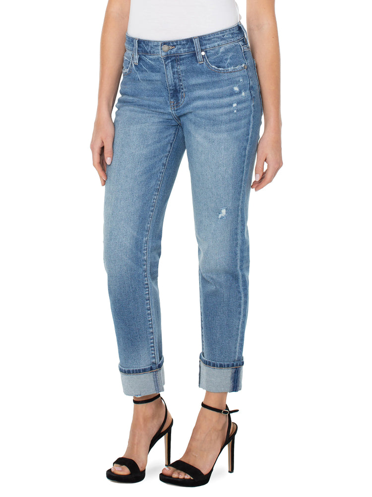 Light-wash blue jeans, rolled cuffs, distressed details. Model wears black heels.