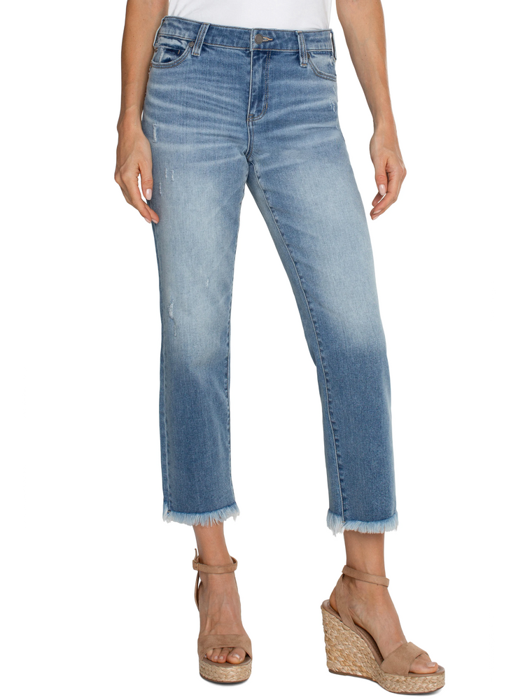 Light wash denim cropped straight leg jeans with frayed hems. Distressed areas visible. Model wears tan wedge sandals.