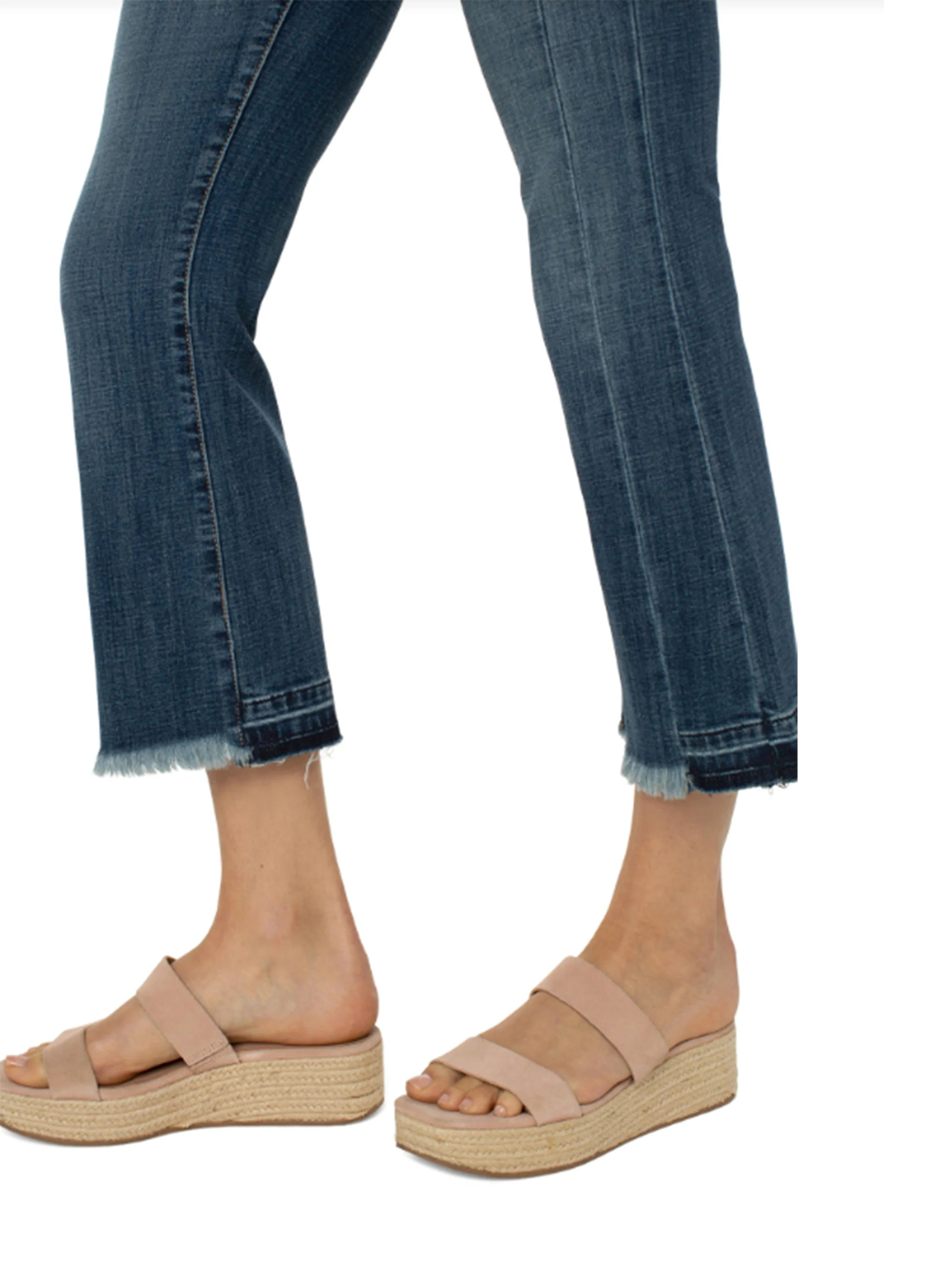 Mid-rise, cropped, dark-wash jeans with frayed hems. Model wears them with light beige platform sandals.