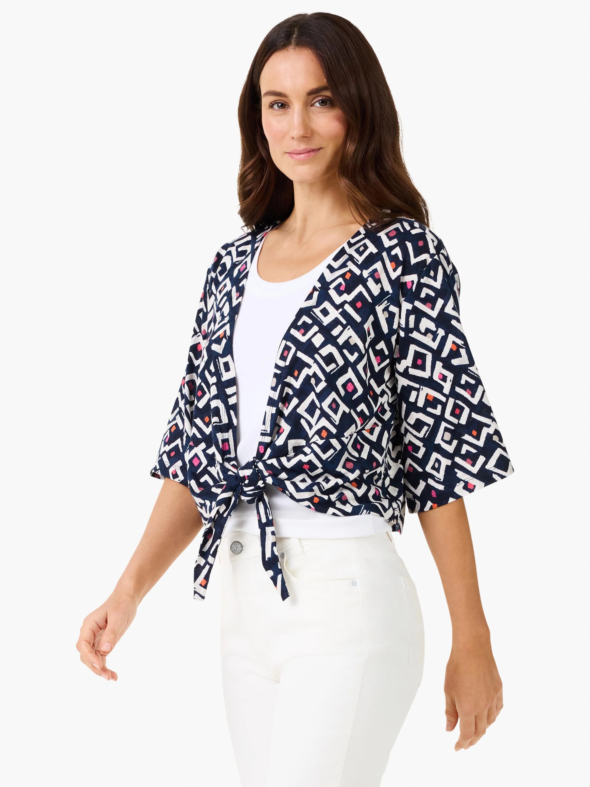 Indigo cardigan with white, pink, and orange geometric angle pattern. Short sleeves, tied at waist over white top.