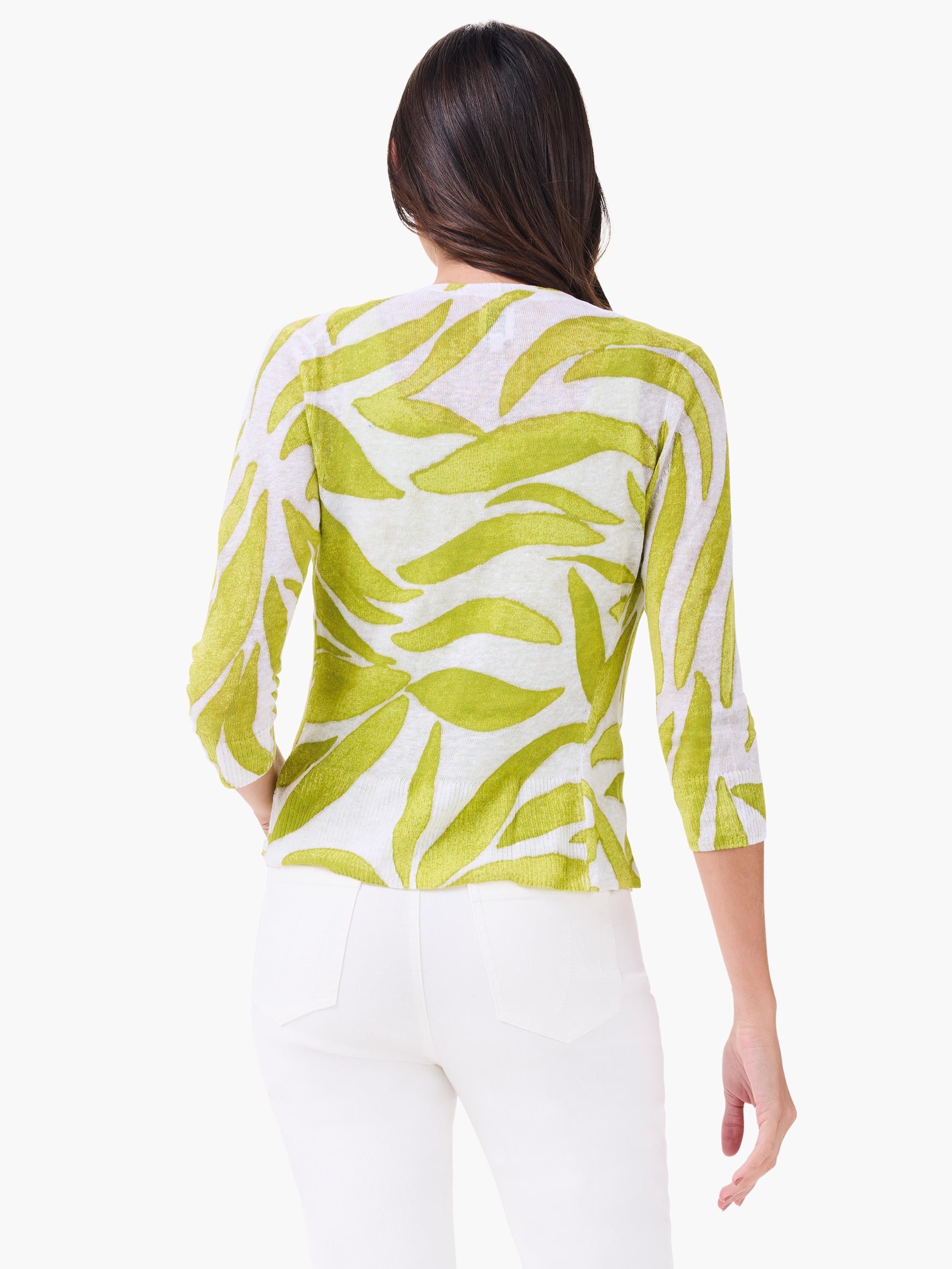 White cardigan with lime green abstract leaf pattern, 3/4 sleeves. Model from behind.