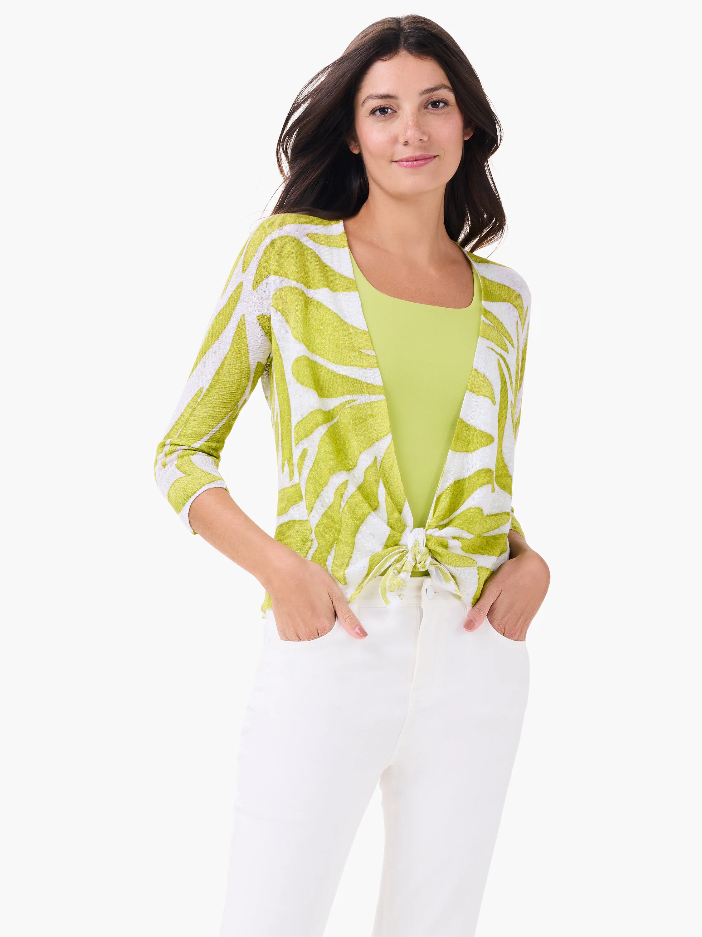 White open-front cardigan with bright green abstract leaf pattern, tied at the waist. Worn over a matching green top.