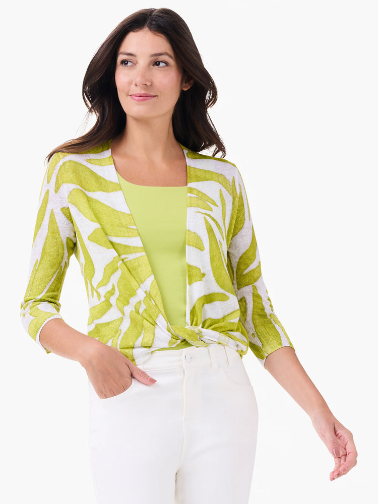 Lime green and white abstract print cardigan with 3/4 sleeves, styled tied at the front over a green tank top.