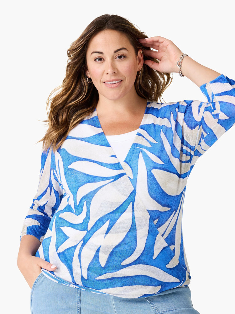 Blue and white open cardigan with an abstract leaf pattern, 3/4 sleeves, worn over a white top.