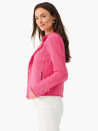 Bright pink knit jacket with fringe trim on edges, a zip pocket, and decorative buttons on the cuffs.