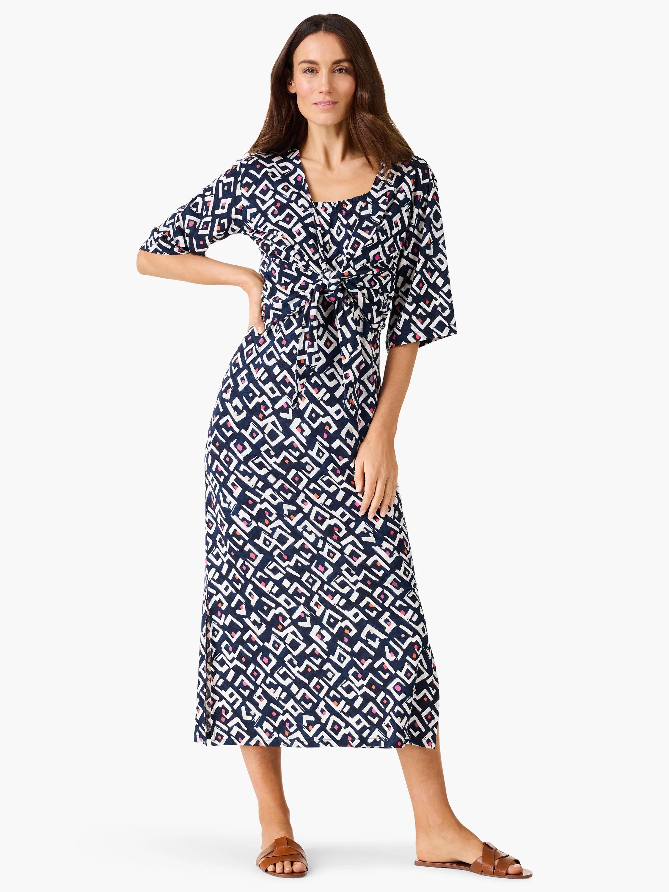 Midi indigo dress with white geometric pattern, pink/orange accents, tie waist, and elbow sleeves.