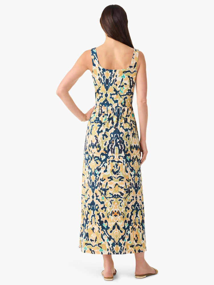Back view of a sleeveless maxi dress. Abstract pattern in navy, gold, beige, and teal, with a square back and gathered waist.