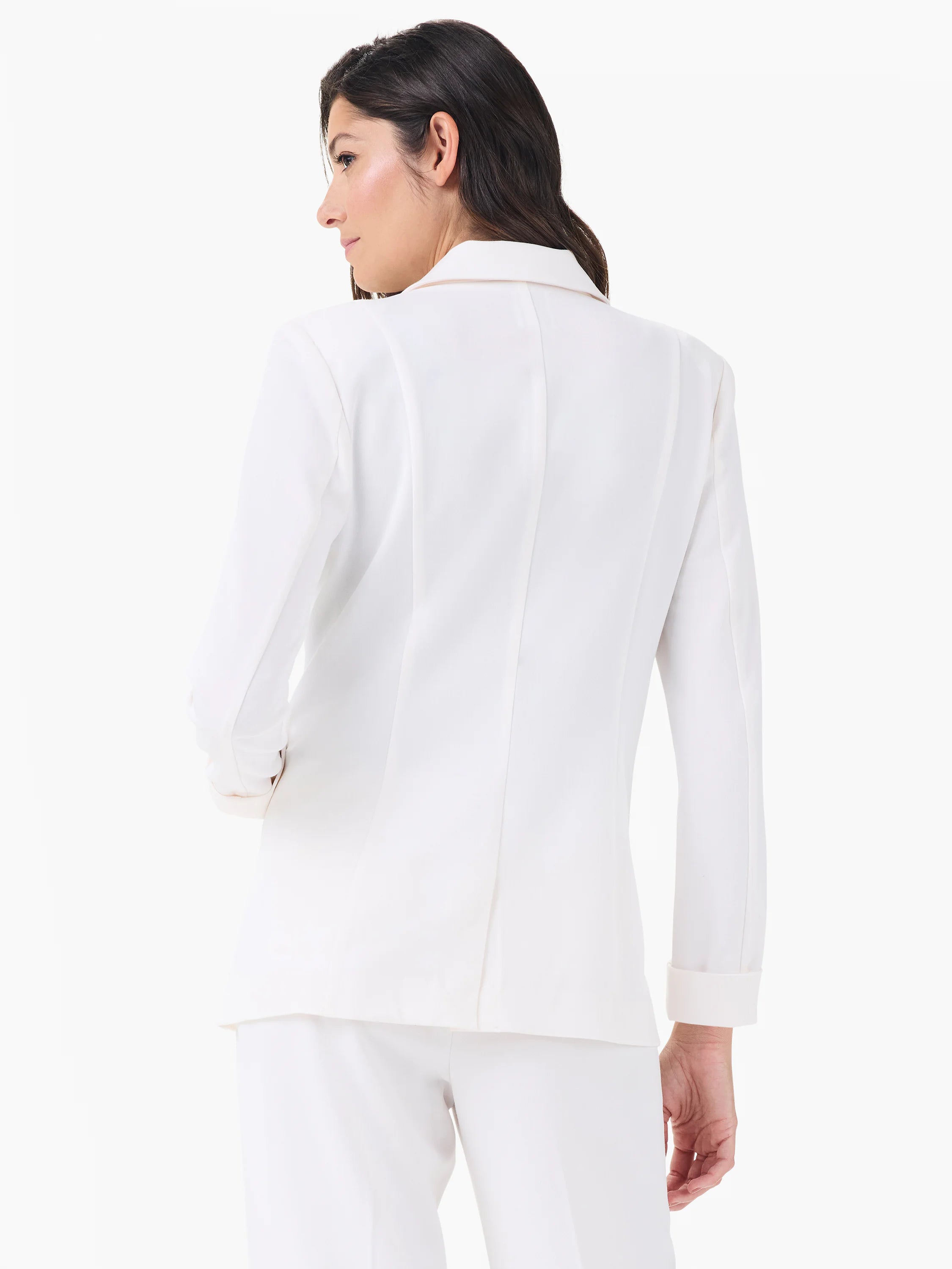 White structured blazer, back view. Cuffs are rolled, showing a light nude lining.