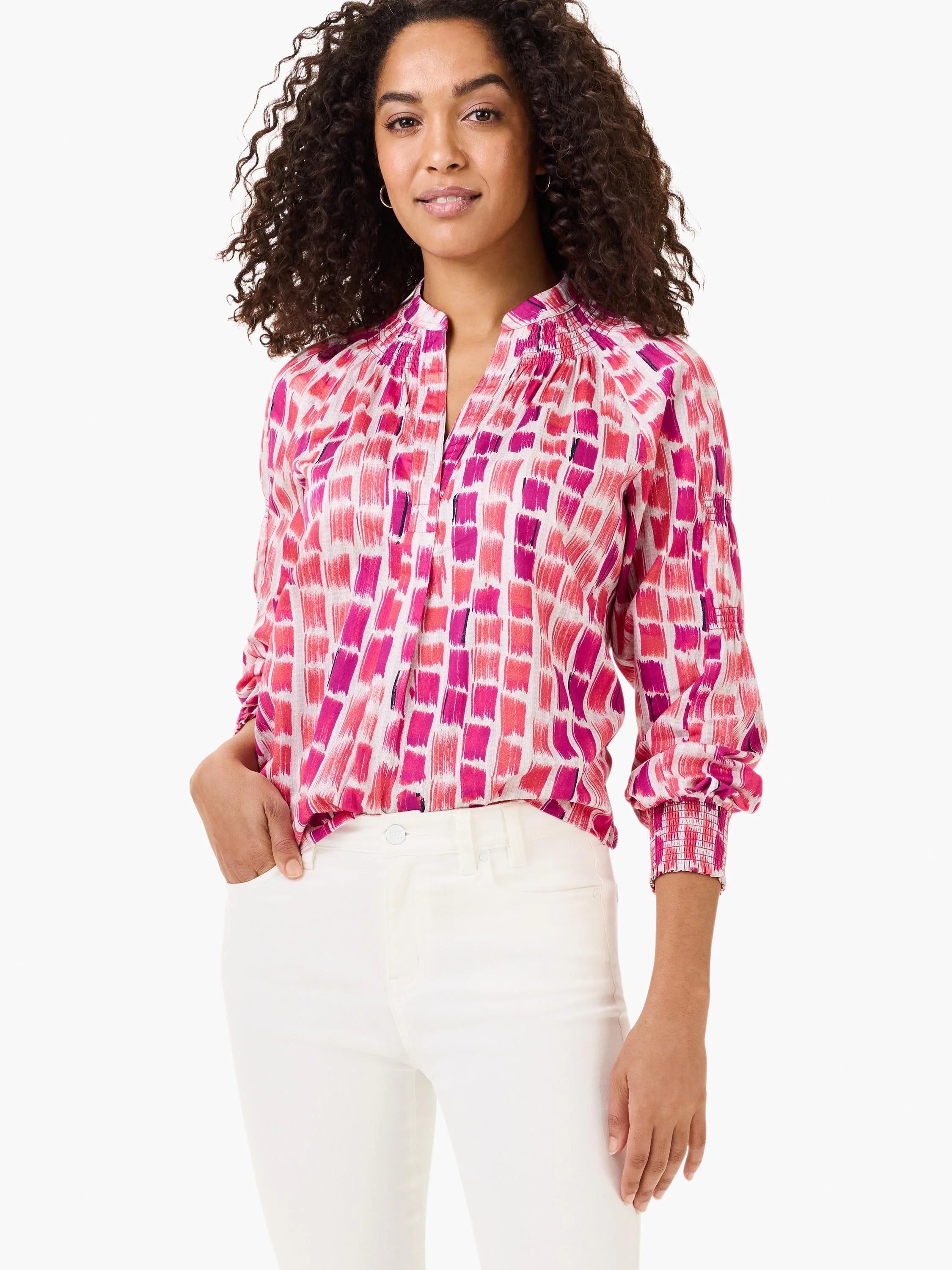 White blouse with pink and fuchsia brushstroke pattern, smocked collar and cuffs, long sleeves.