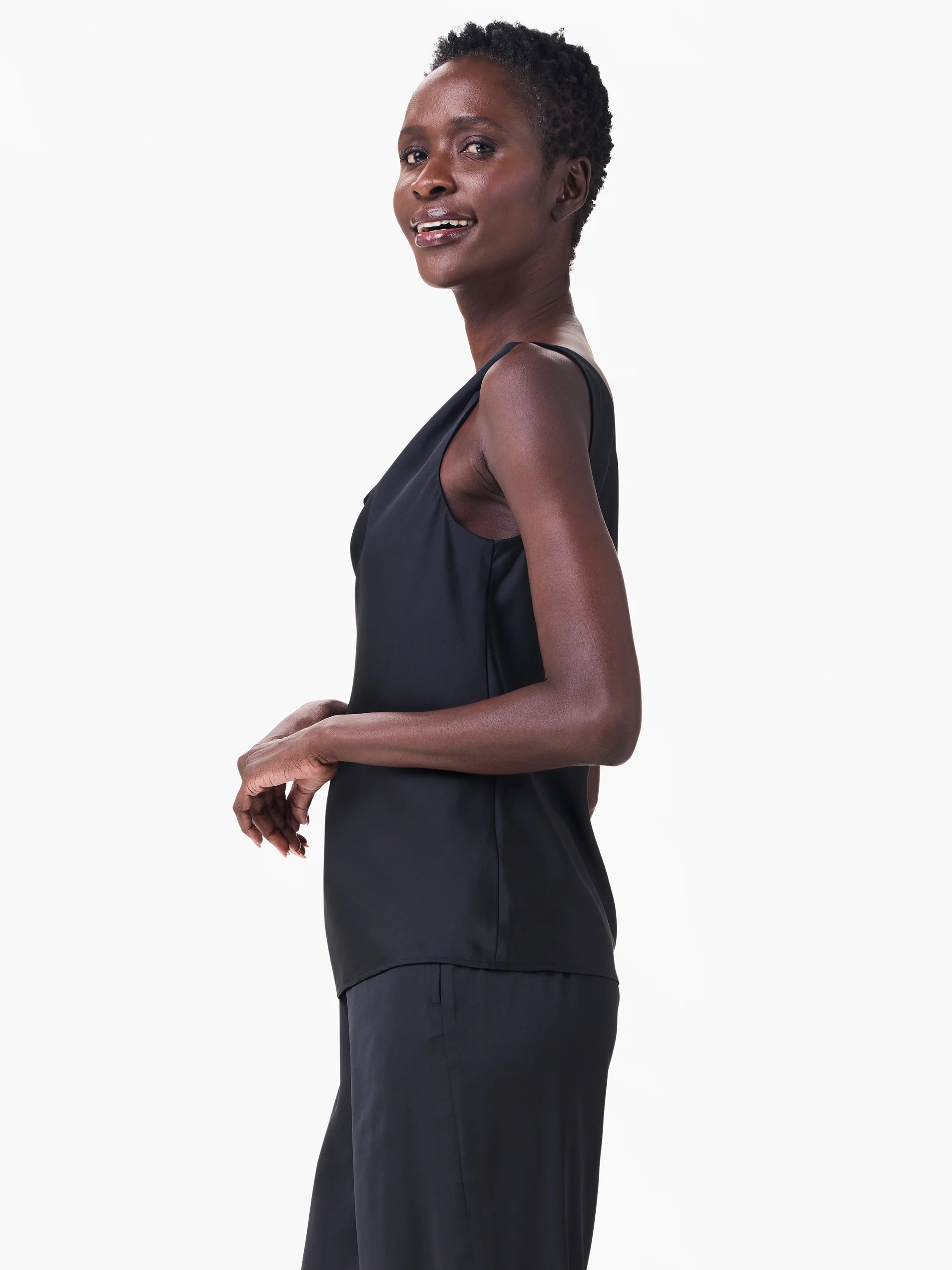 Black sleeveless tank with an asymmetric draped neckline, modeled by a woman.