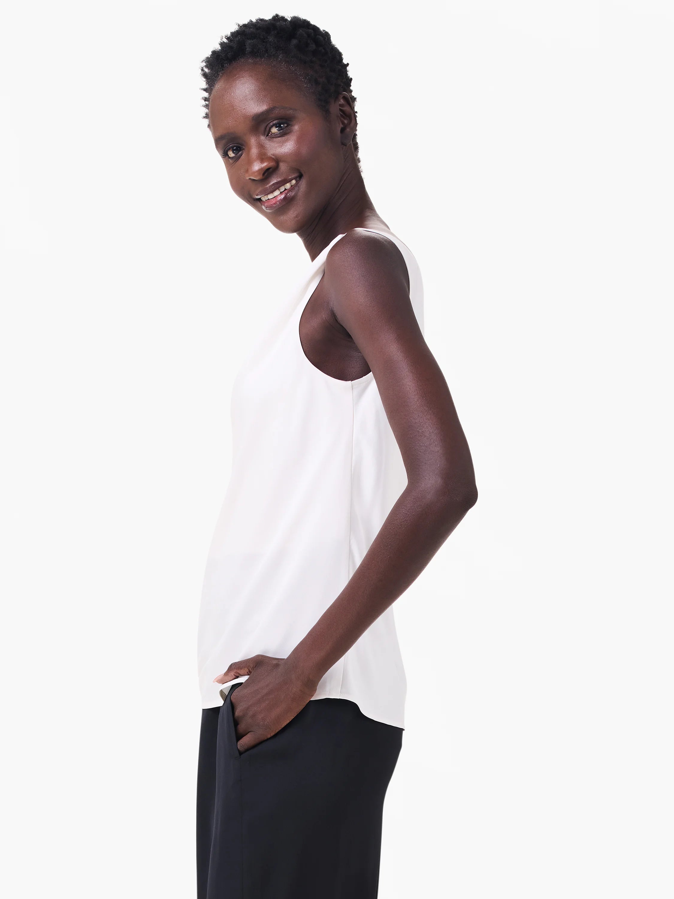 Off-white sleeveless tank top with a drapey fit, shown on a model wearing dark pants.