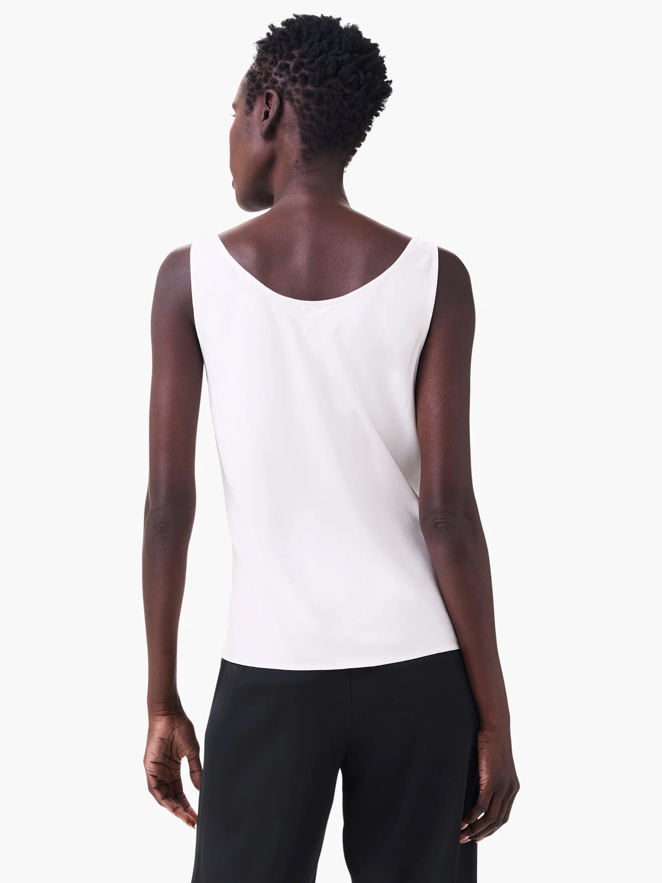 White sleeveless tank from behind. Smooth, draped fabric with a wide scooped back neckline.