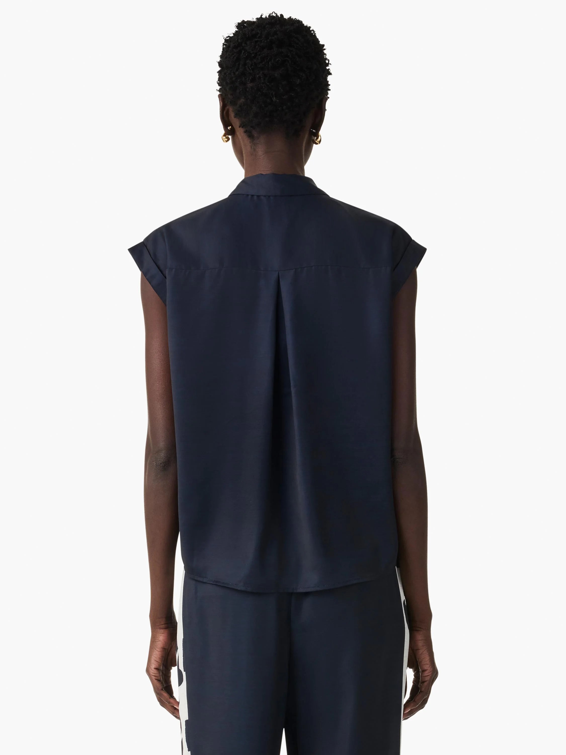 Back view of navy blue sleeveless collared top with rolled cap sleeves and a center back pleat.