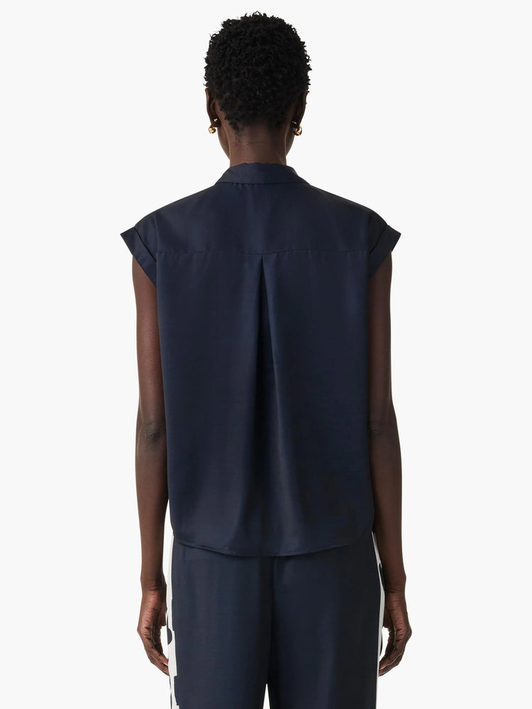Back view of navy blue sleeveless collared top with rolled cap sleeves and a center back pleat.
