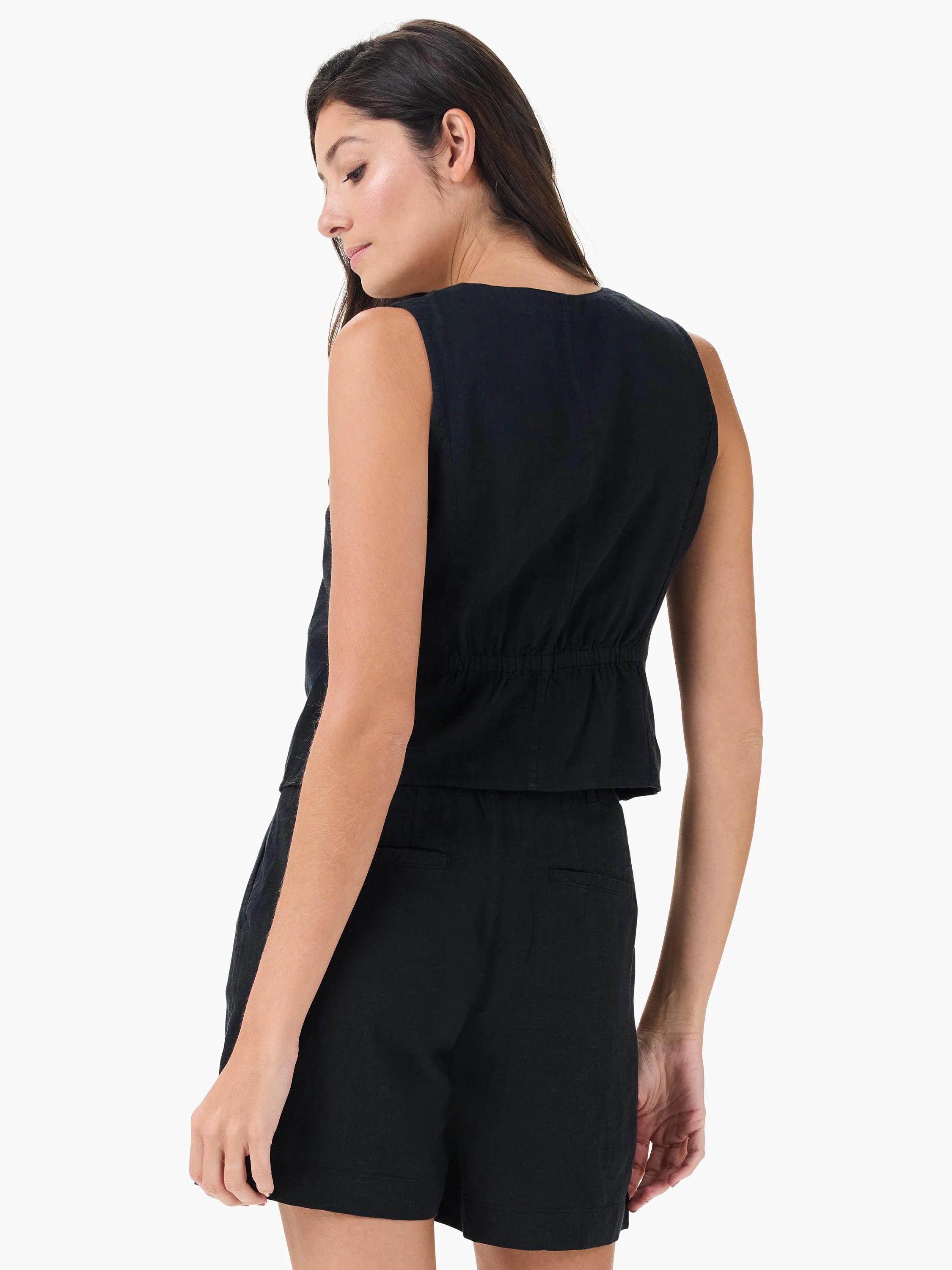 Black sleeveless linen vest, cinched waist, shown from back. Model also wears black shorts.