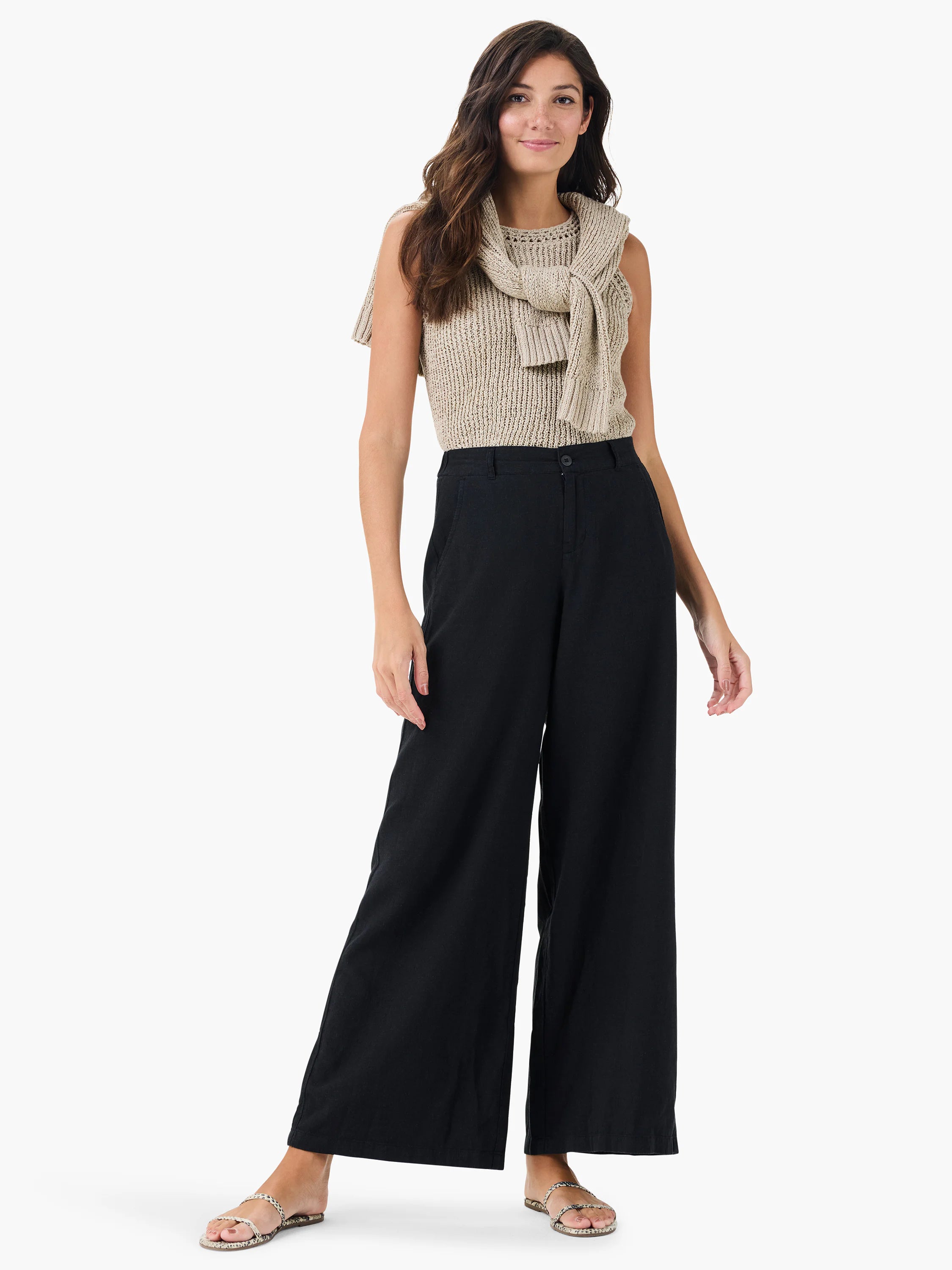 Black wide-leg linen trousers on a model.  The model also wears a light beige knit top and neutral sandals.