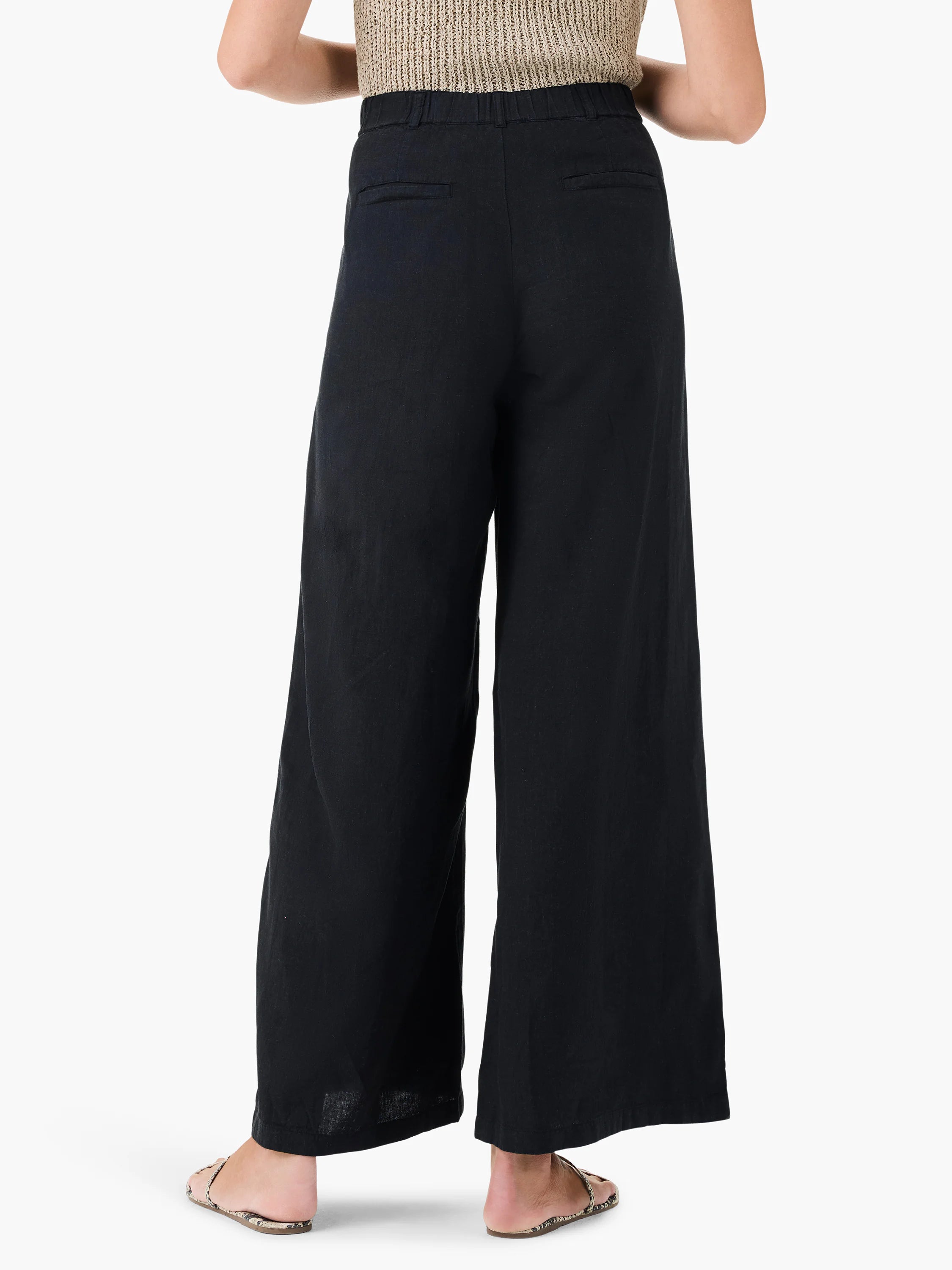 Here's alt text under 125 characters:
Black linen wide-leg trousers; elastic waistband, back pockets.  Model wears them...