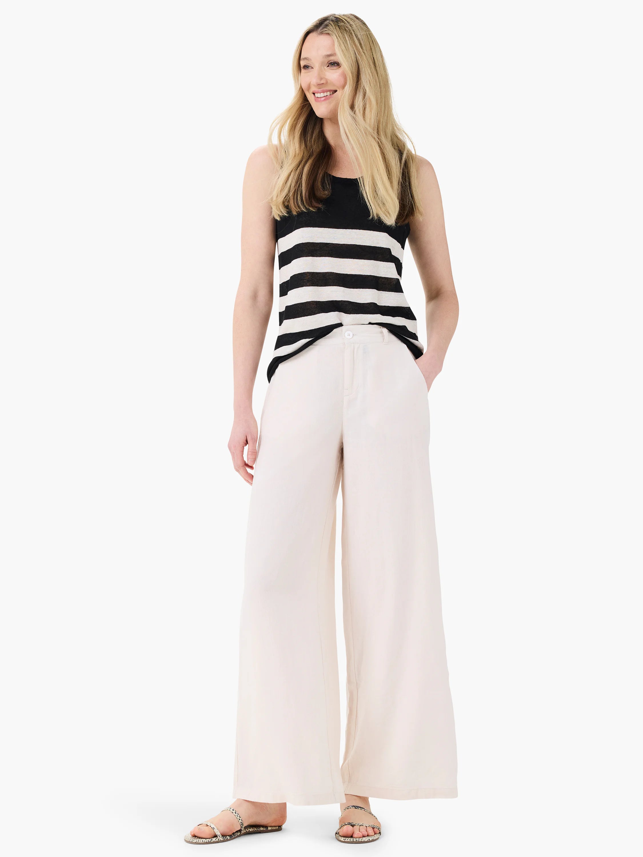 Off-white wide-leg linen trousers; model shown wearing them with a black and white striped tank top and snakeskin sandals.