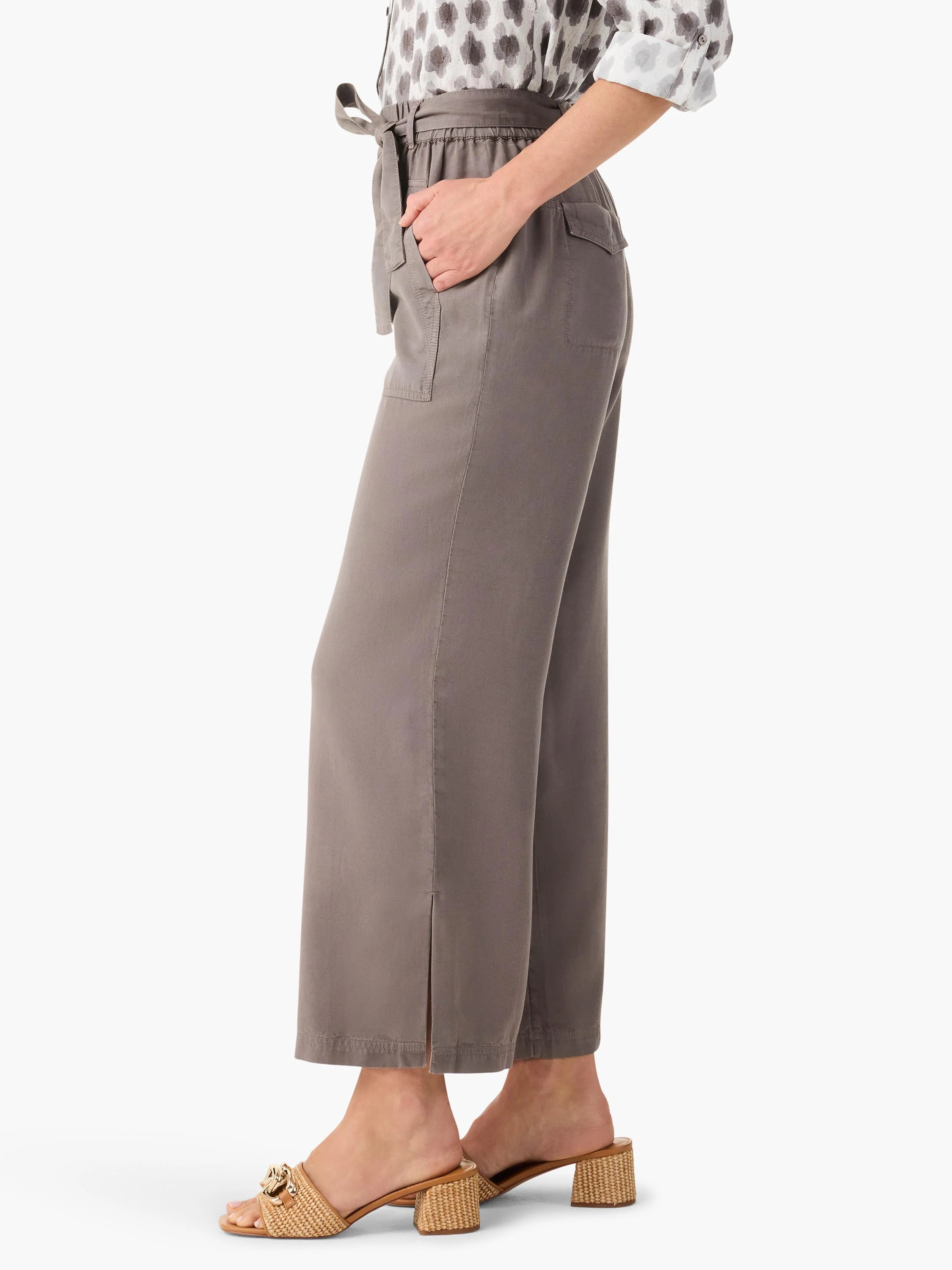 Taupe wide-leg utility pants with tie-belt waist, front patch pockets, and small side slits at the hem.