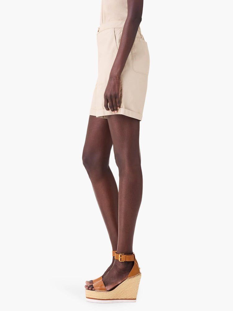 Beige poplin shorts shown on a model. Shorts have cuffed hems and pockets. Model wears brown wedge sandals.
