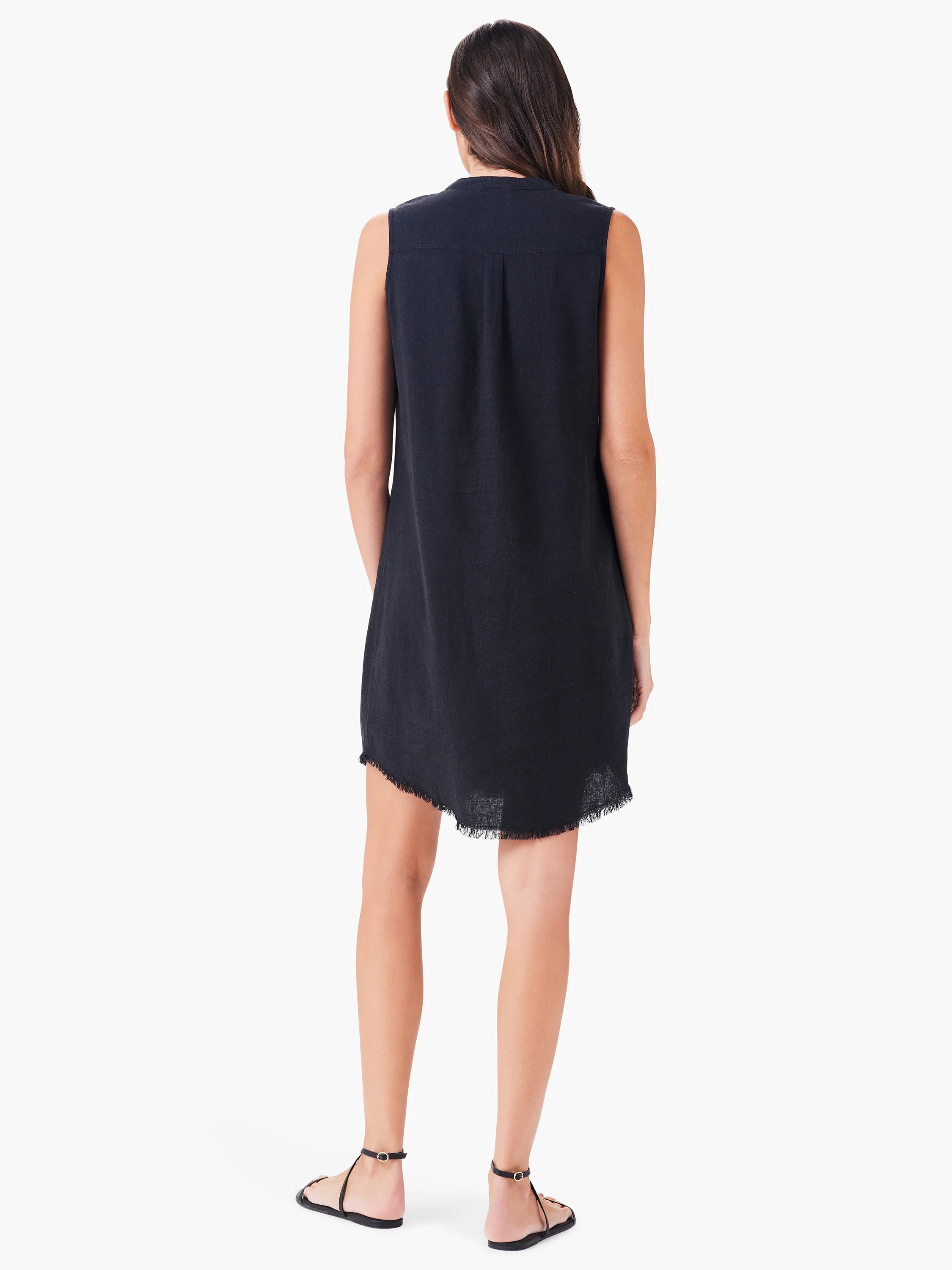 Black sleeveless linen dress, hem with frayed edges. Model shown from behind.