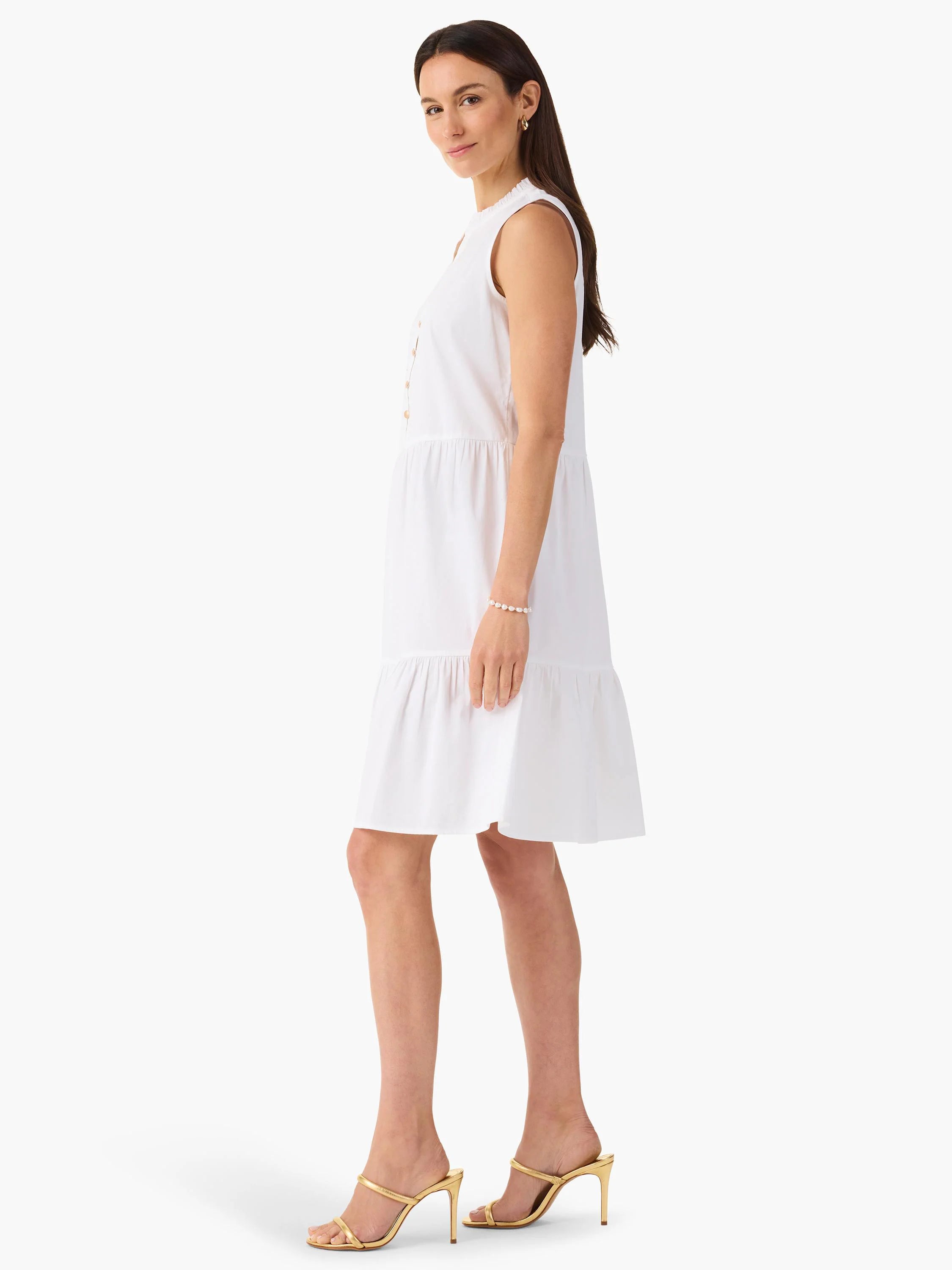 White sleeveless tiered mini dress with pearl-like buttons.