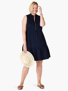 Navy sleeveless tiered dress with gold buttons down the front.  The model is wearing brown sandals.
