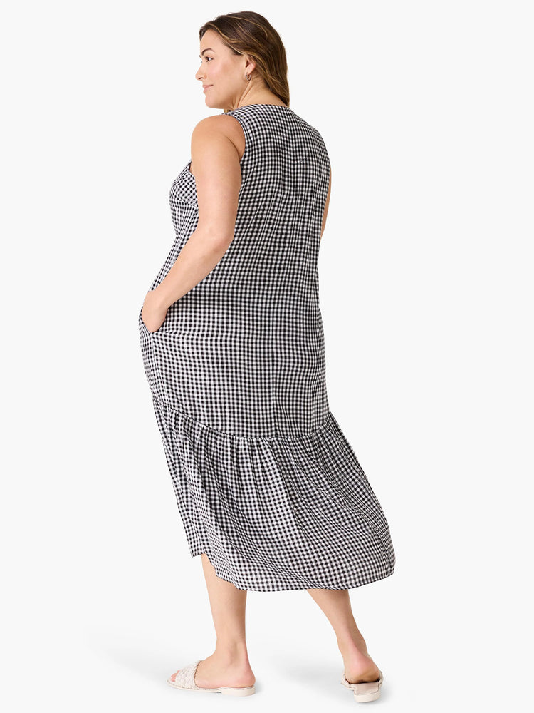Black and white gingham midi dress; sleeveless, back view, tiered ruffle hem, pockets.