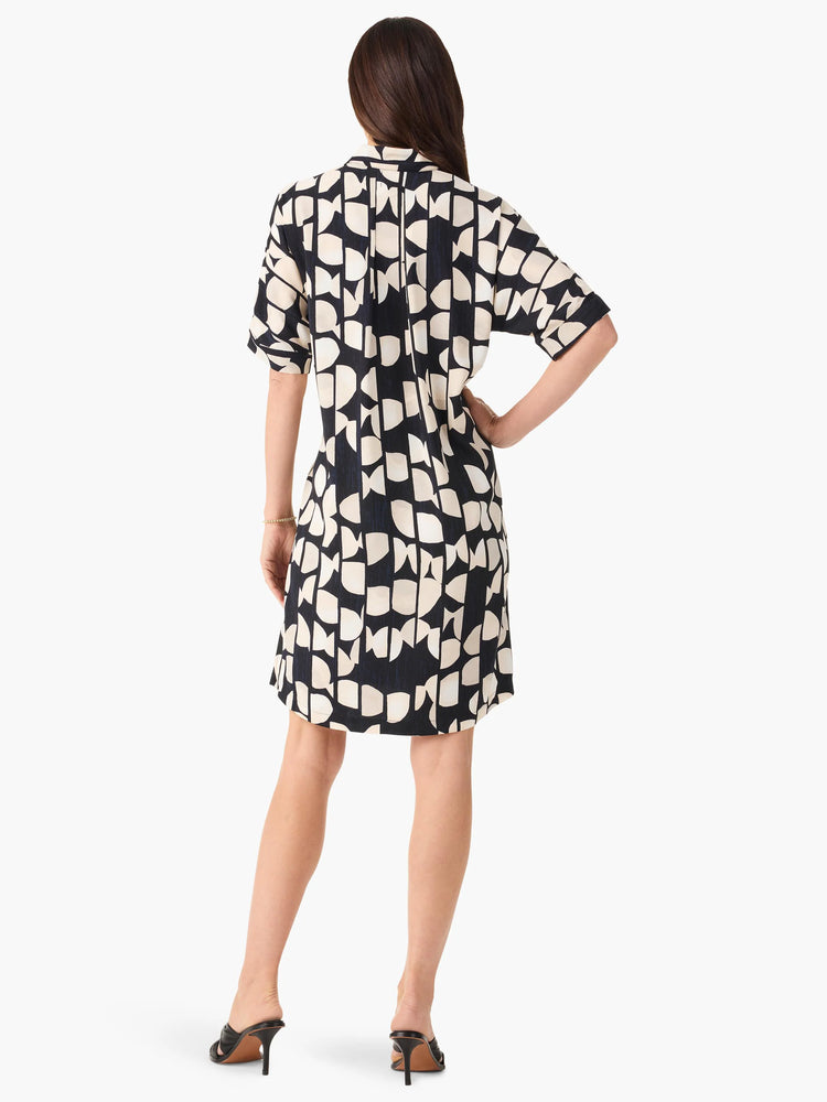 Here's alt text for the image, under 125 characters:
Black short-sleeved dress with a beige abstract print. Rear view.