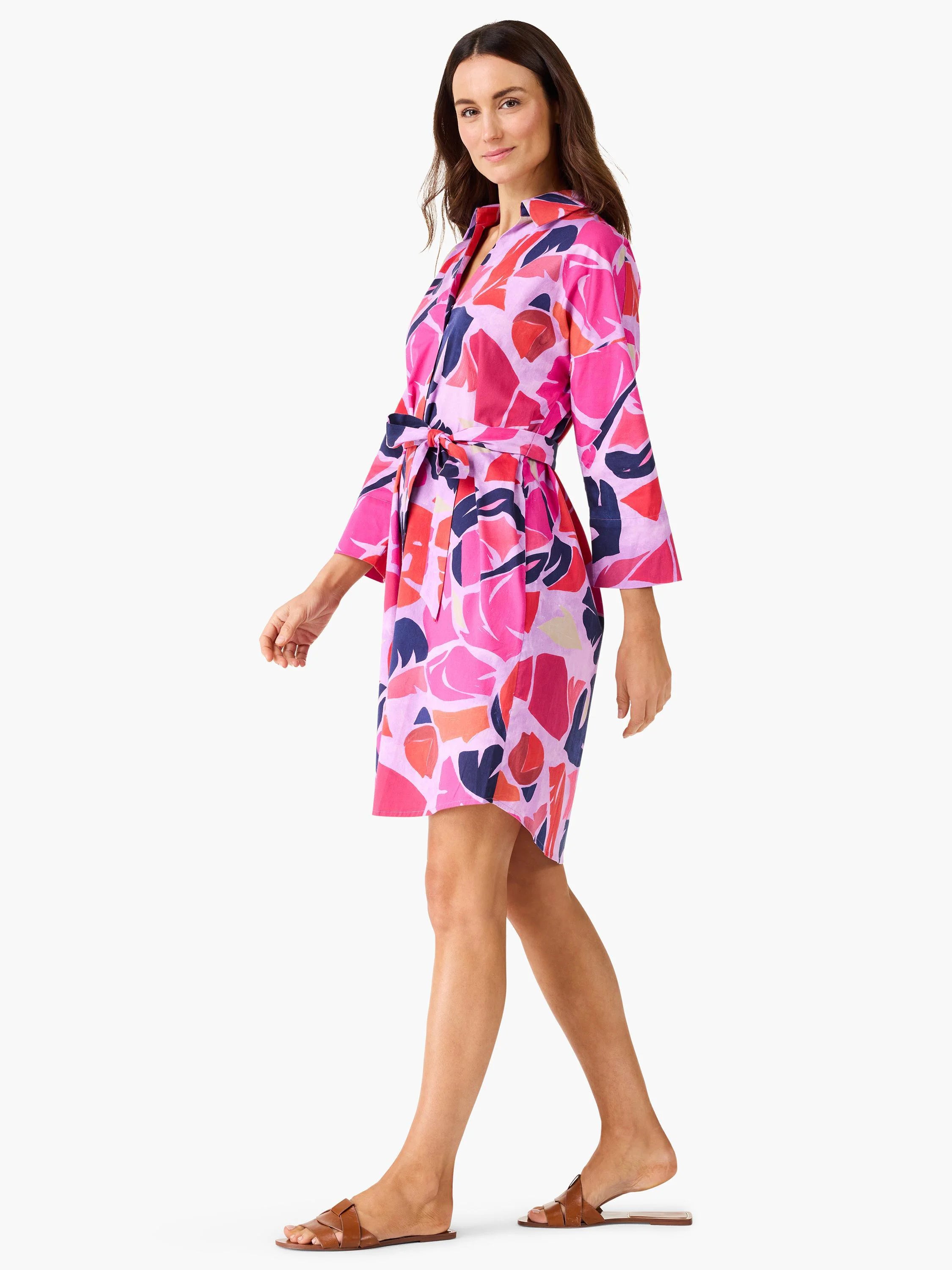 Pink shirt dress with abstract pink, red, and dark blue leaf pattern, belted waist, and three-quarter sleeves.