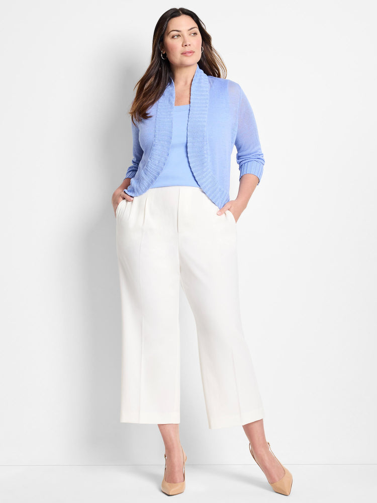 This sheer periwinkle open-front cardigan features a ribbed shawl collar and elbow sleeves, styled with white wide-leg pants.