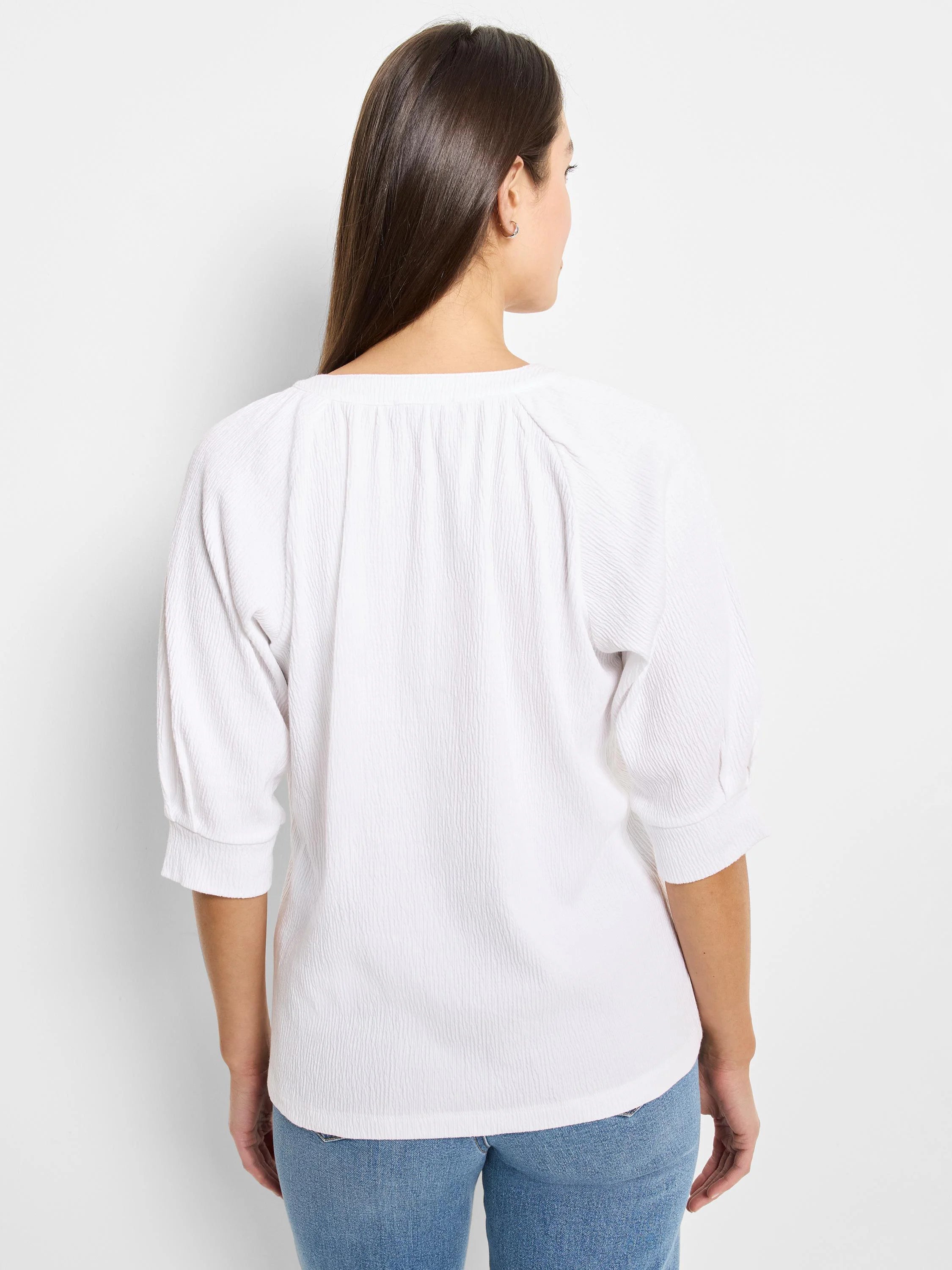 White, textured knit top with 3/4 sleeves and a slightly scooped neckline. View from the back.
