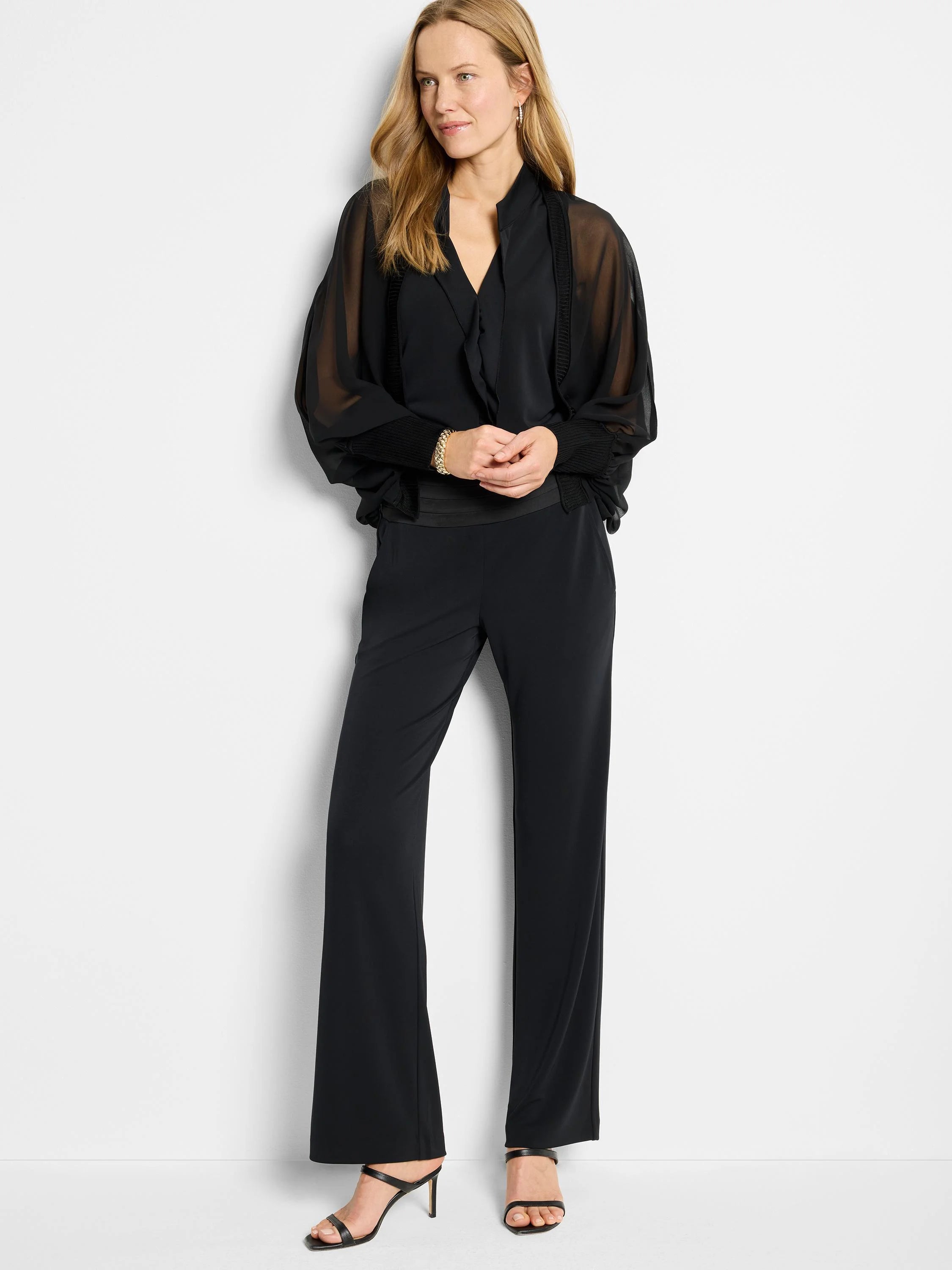 Black knit crepe tank; ruffle neckline, sheer balloon sleeves with ribbed cuffs.
