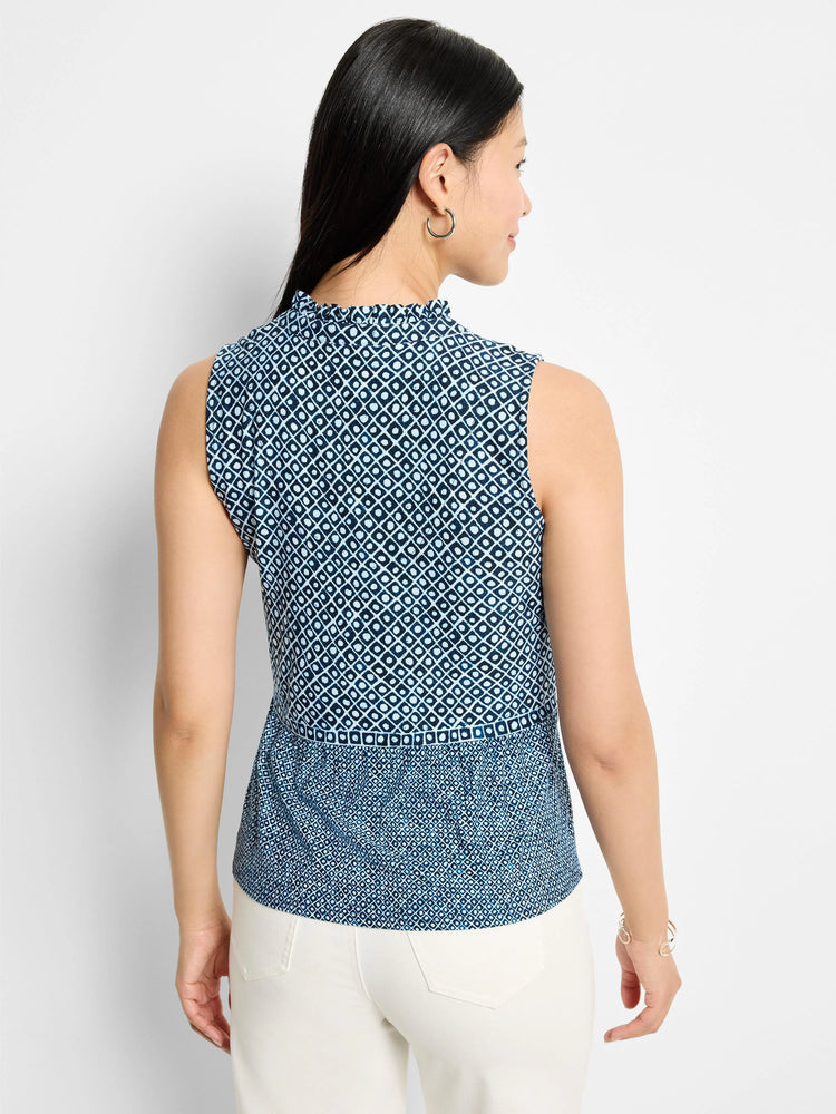 Sleeveless knit tank; blue and white geometric pattern. Mock neck, ruffled neckline. Slightly flared hem.