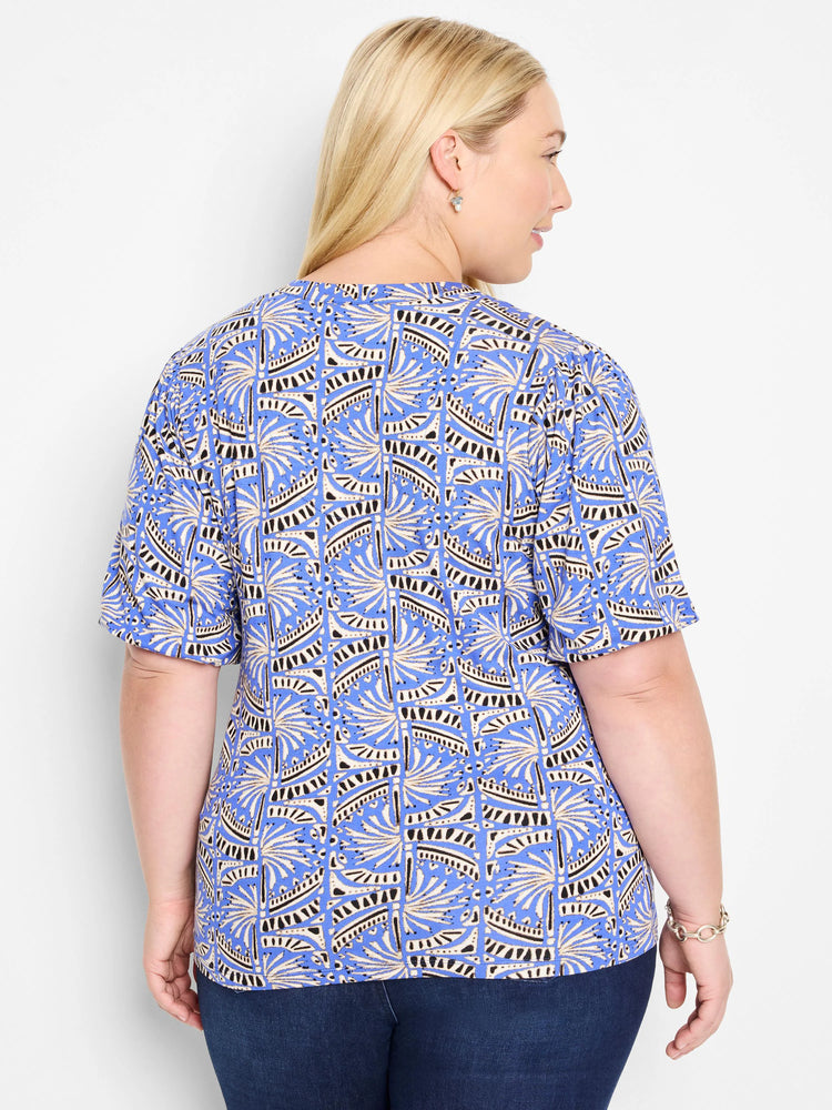 Blue short-sleeve top with a repeating geometric pattern in beige and black.