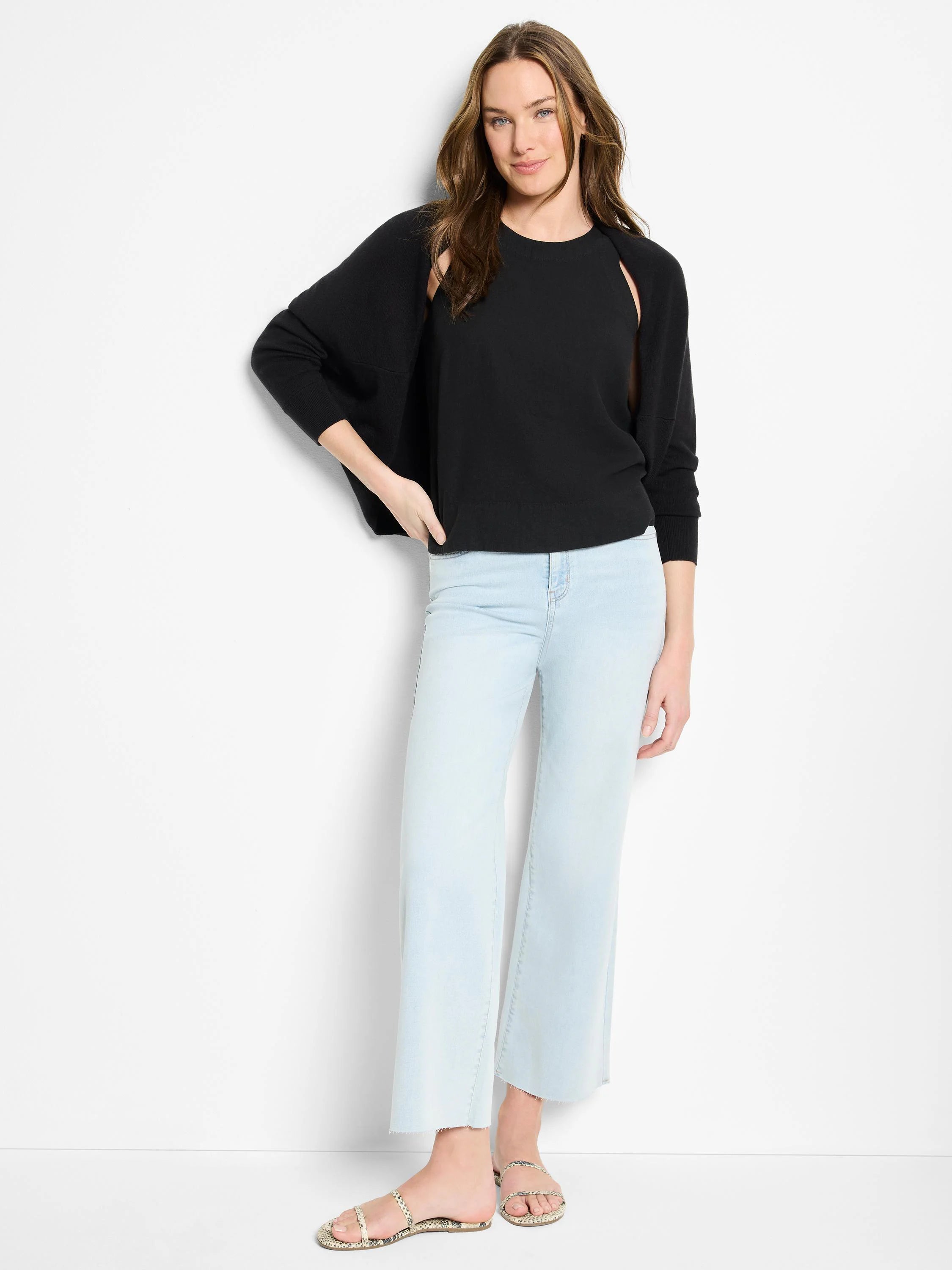 Black cotton cashmere shrug cardigan. Model shown wearing it over a black top.