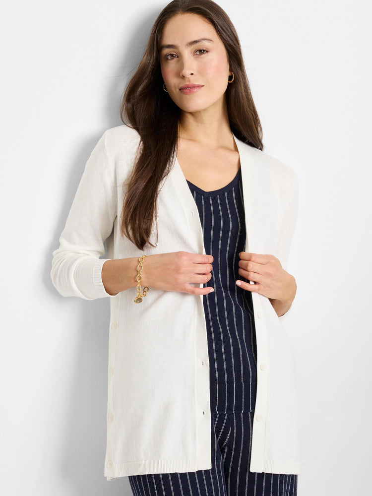 Off-white cardigan, long sleeves, button front. Model wears it over a navy pinstripe top.