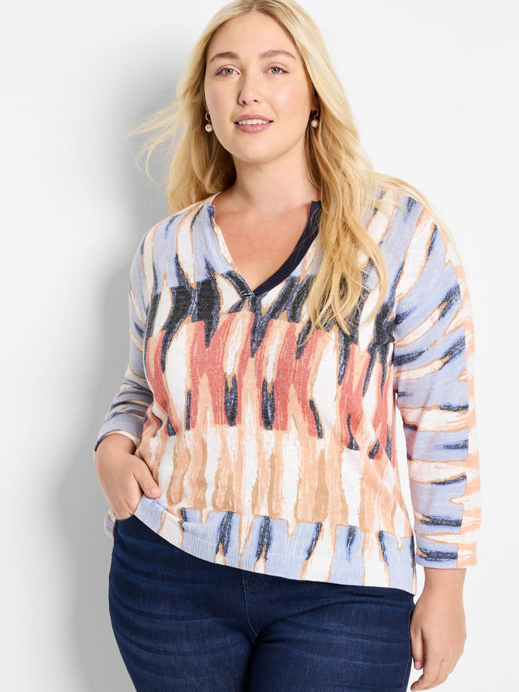 Crisscross V-neck sweater in blue, peach, and cream abstract print. Three-quarter sleeves.