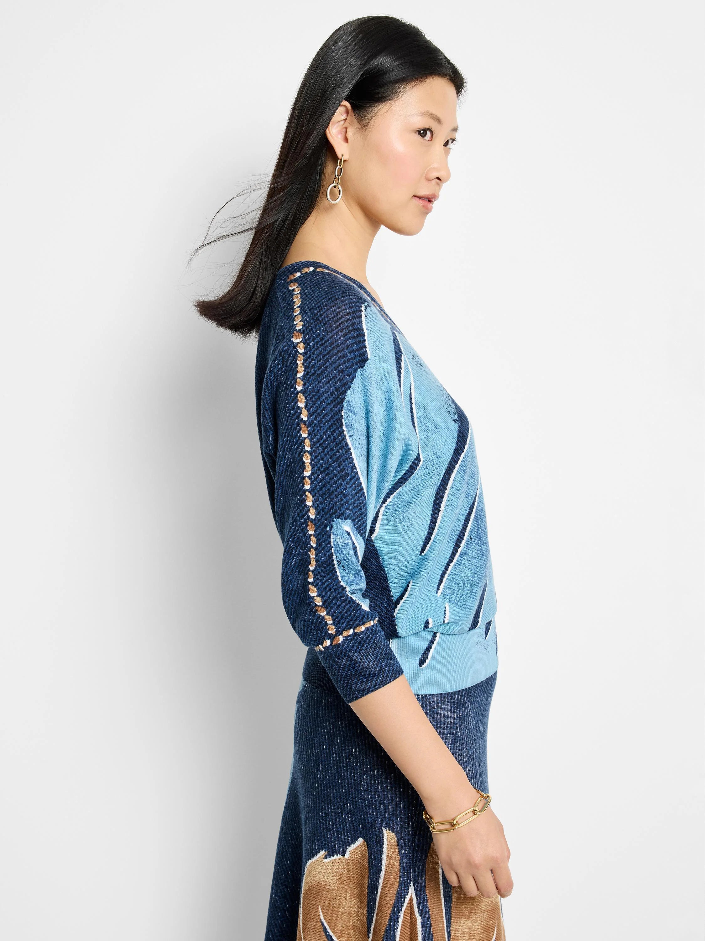 V-neck sweater, light & dark blue abstract print, brown accents. Three-quarter sleeves.