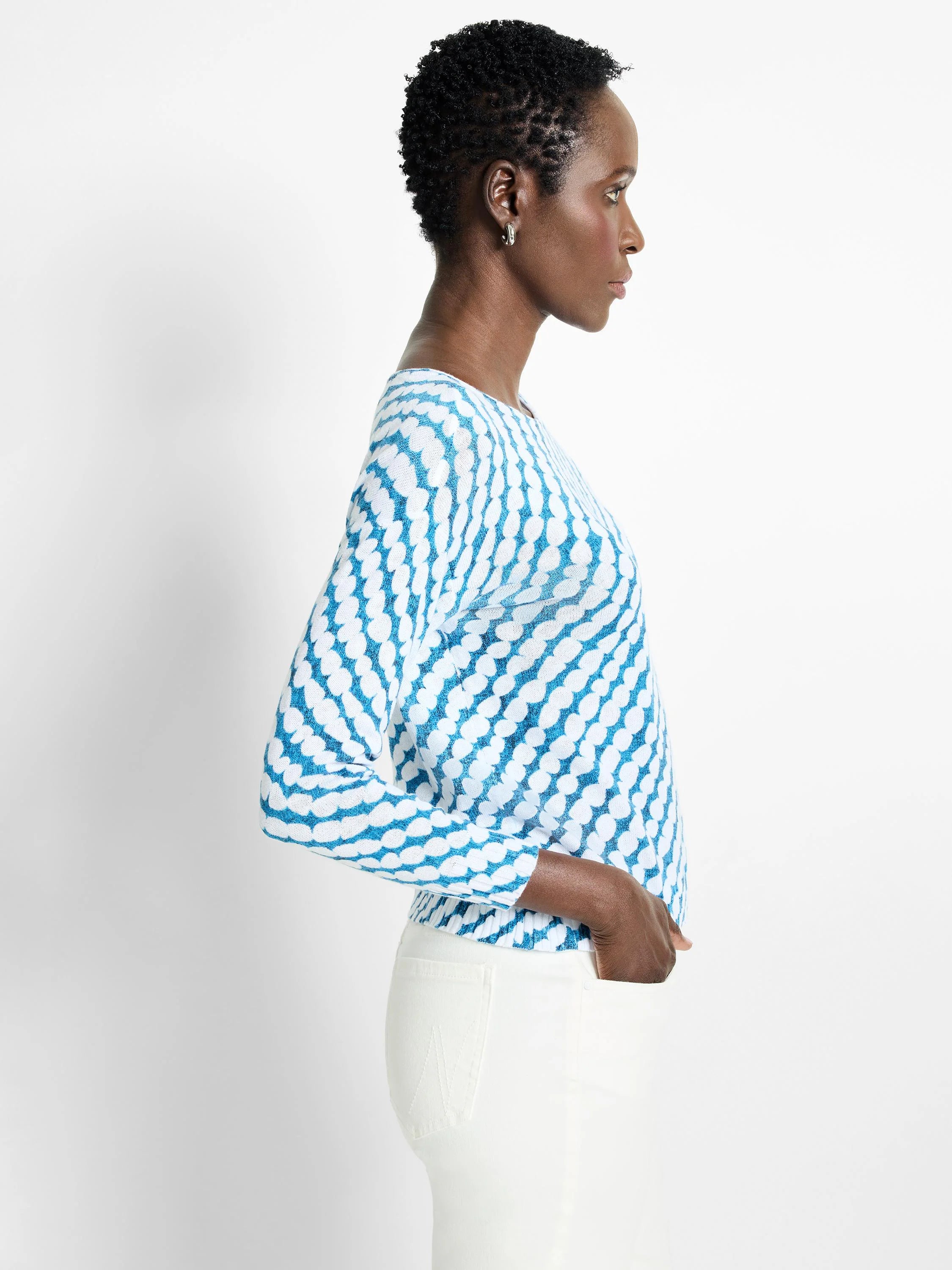 Teal and white patterned long-sleeve sweater. The pattern is a repeating shape.