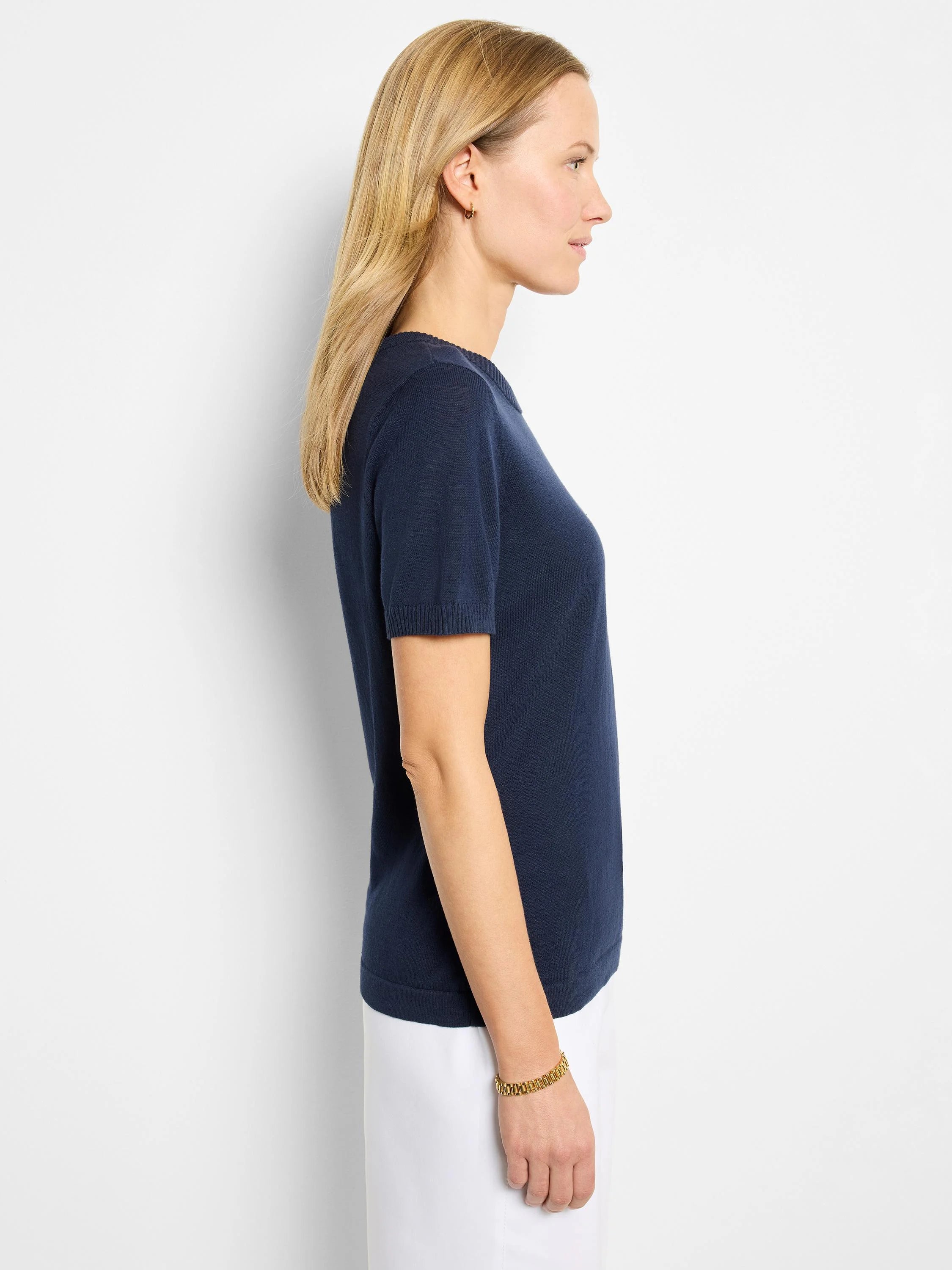 Navy blue, short-sleeved scoop neck cotton sweater tee. Side profile view.