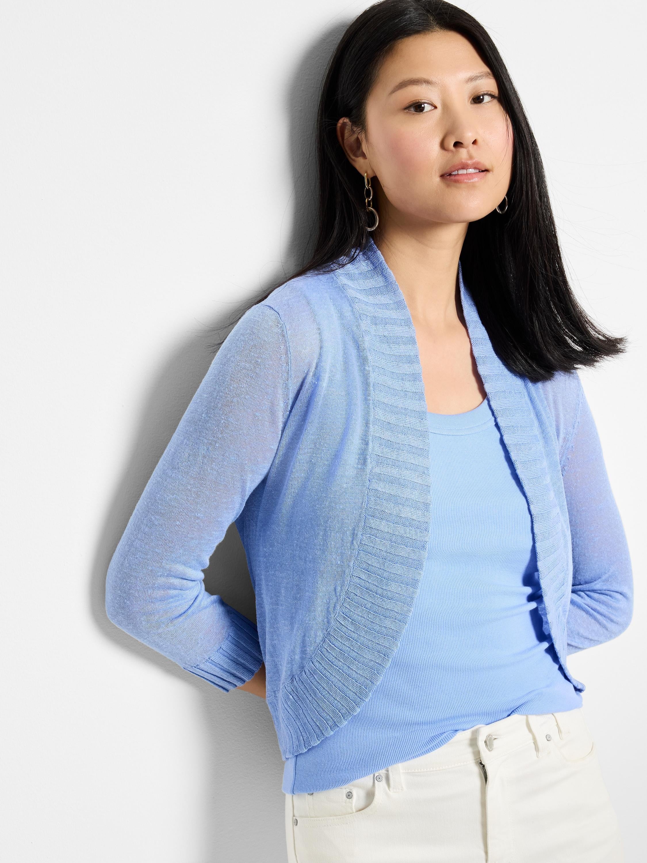 Light blue bolero cardigan. Features an open front, ribbed shawl collar, and long sheer knit sleeves.